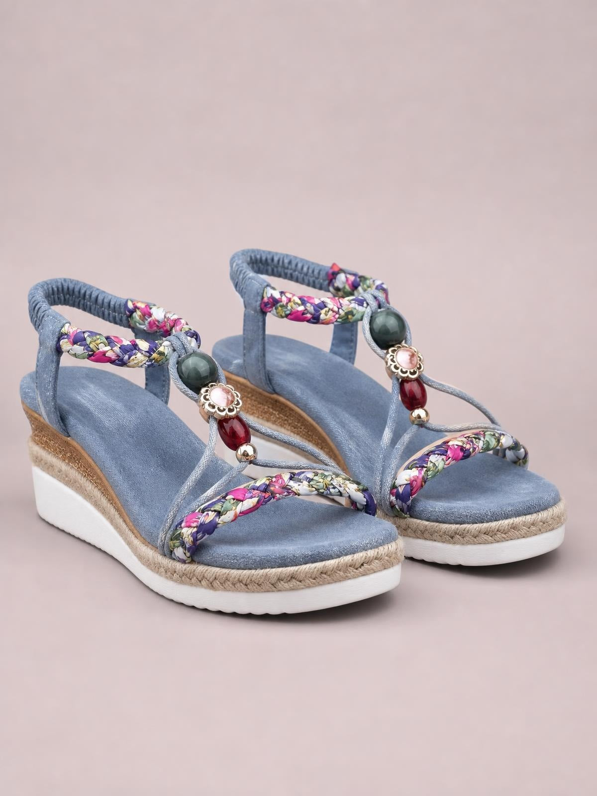 Blue open-toe platform wedge sandals with floral braided straps, beaded embellishments, ankle loops, and straw-wrapped midsoles.