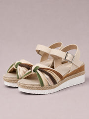 Open-toe beige platform wedge sandals feature green and brown striped bow accents, espadrille trim, ankle straps with buckles, and mid-height wedge heels.