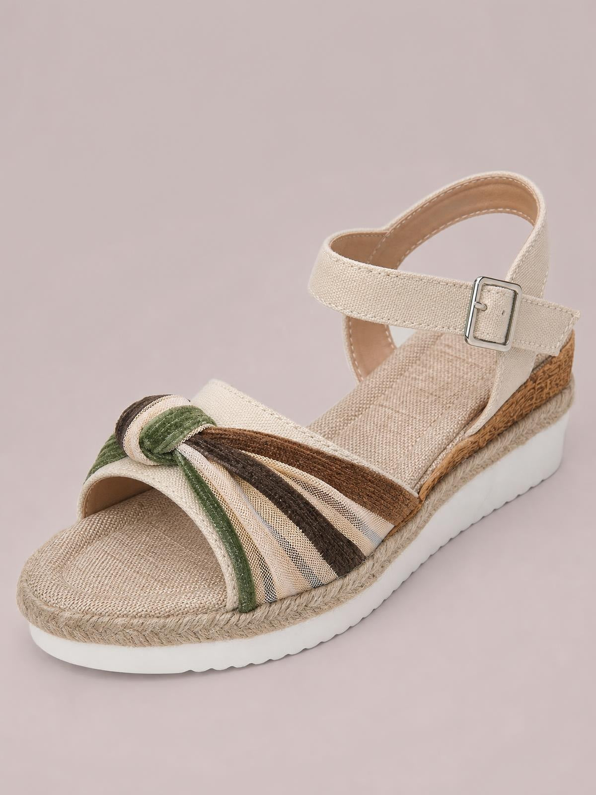 Cream open toe platform wedge sandals feature striped knotted straps, an ankle buckle, espadrille trim, and a comfortable mid-height wedge sole.
