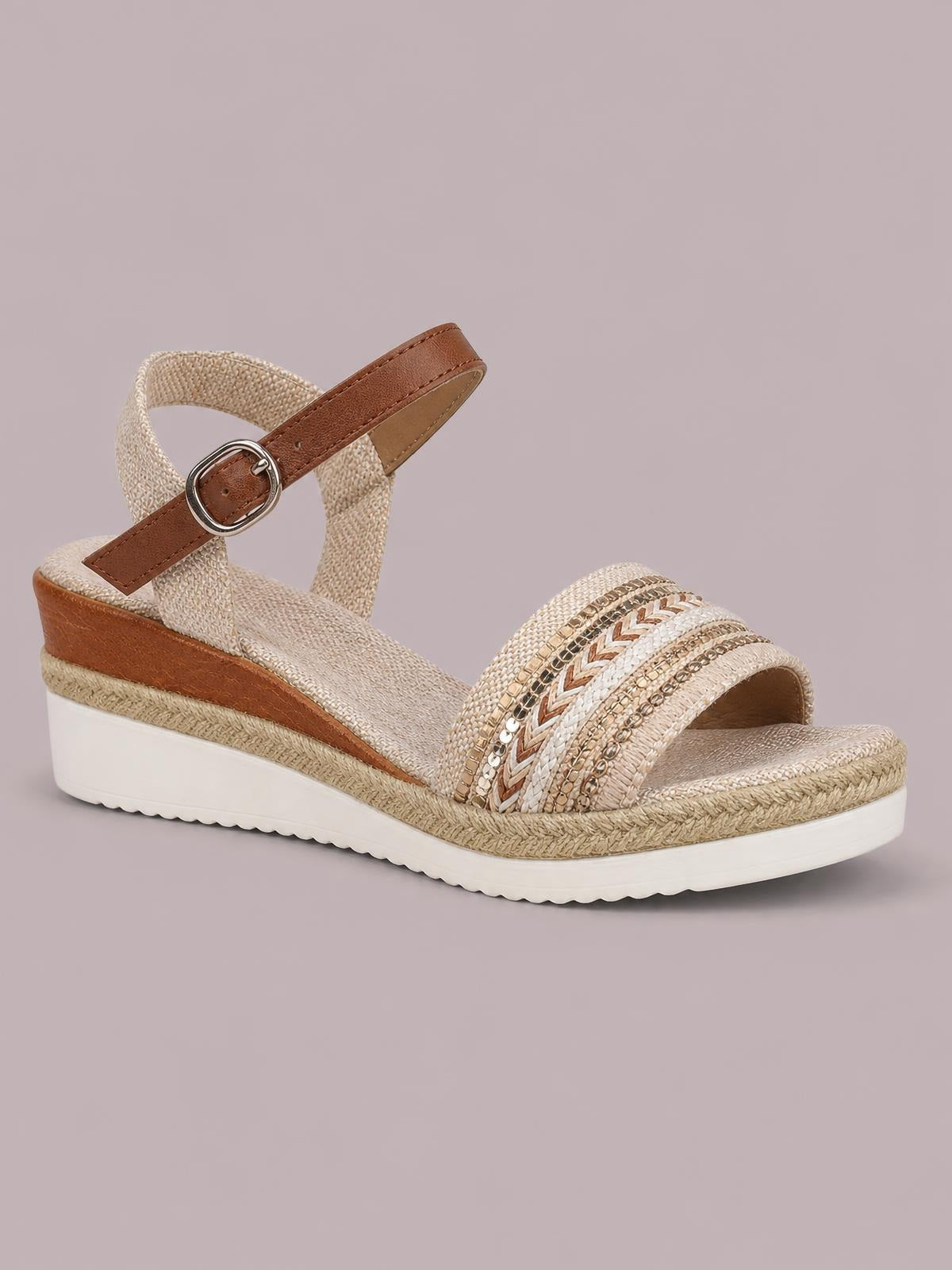 Open toe platform wedge sandals in cream with decorative woven straps, brown ankle buckle, espadrille trim, and a comfortable mid-height wedge sole.