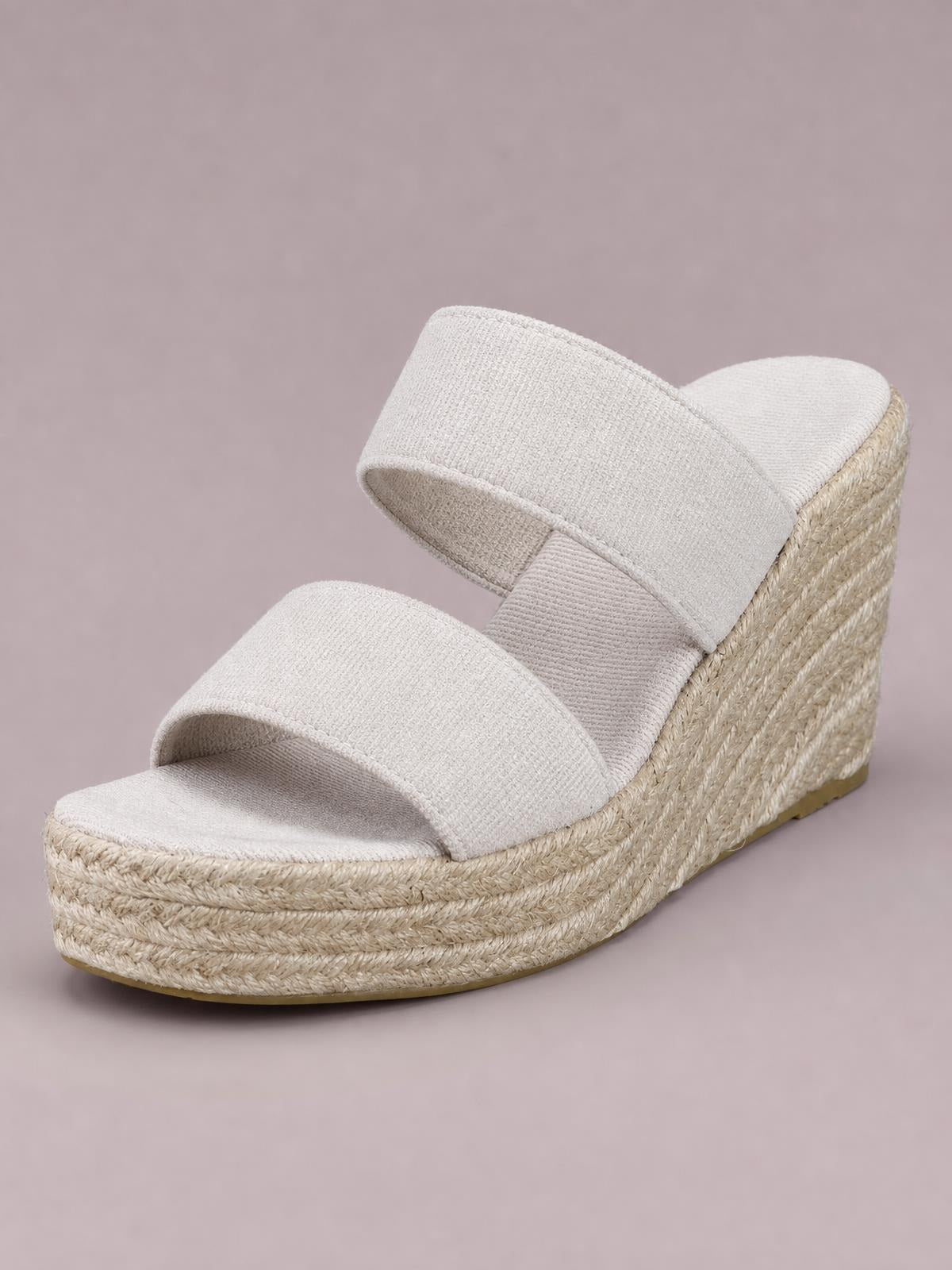 Cream open-toe platform wedge sandals feature two wide crossover straps and a mid-height braided espadrille-style wedge sole.