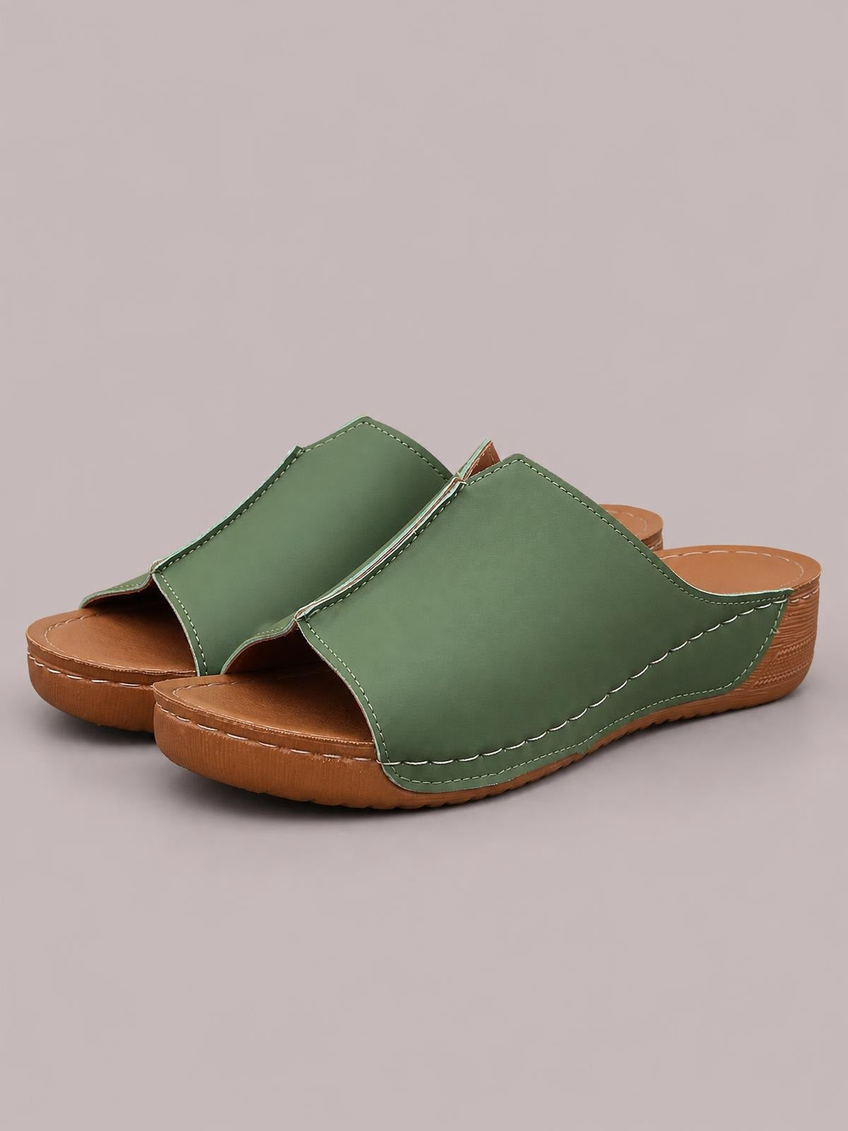 Green open toe wedge sandals with wide PU uppers, contrast stitching, scalloped edges, and low brown wedge soles.