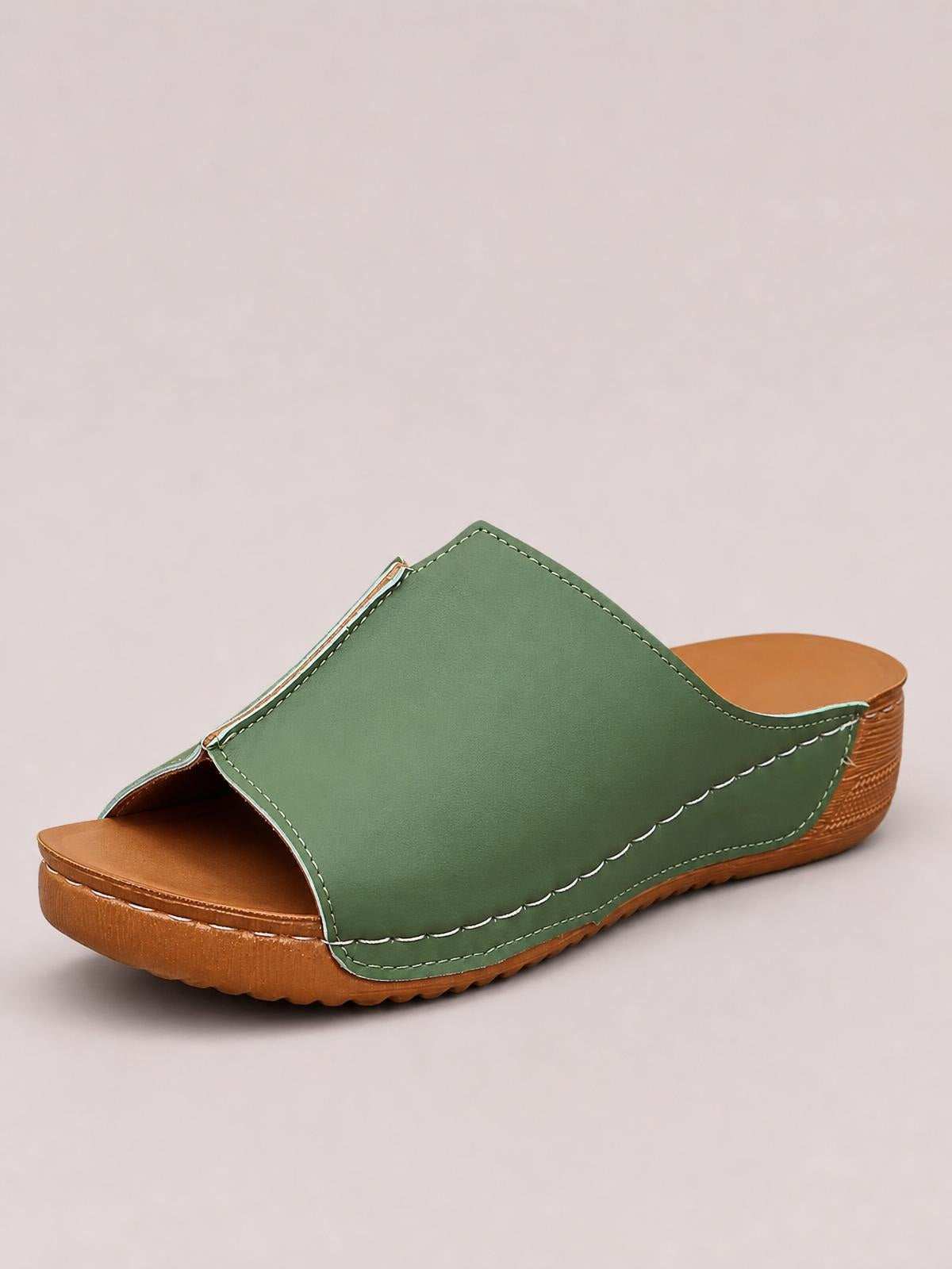 Green open toe wedge sandal with a wide stitched upper, scalloped trim, cushioned brown footbed, and low textured platform sole.