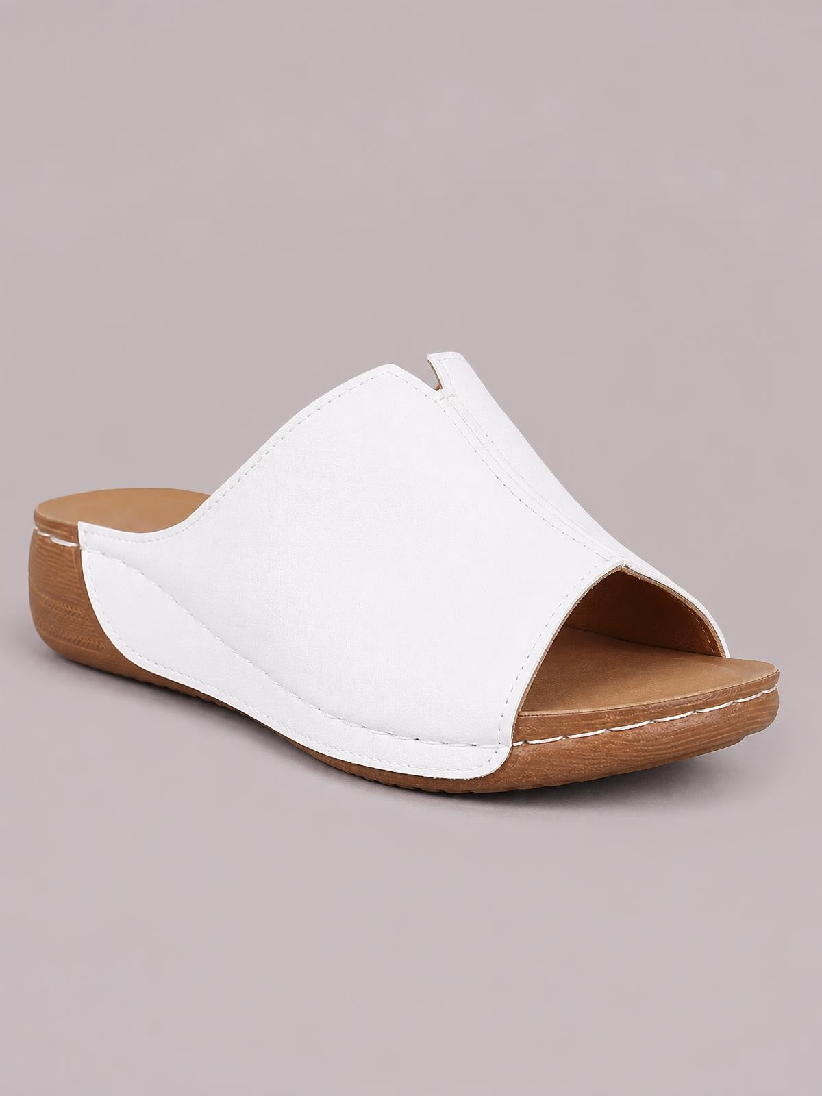 White open-toe wedge sandal with a broad stitched upper, low wedge heel, brown cushioned footbed, and textured rubber sole.
