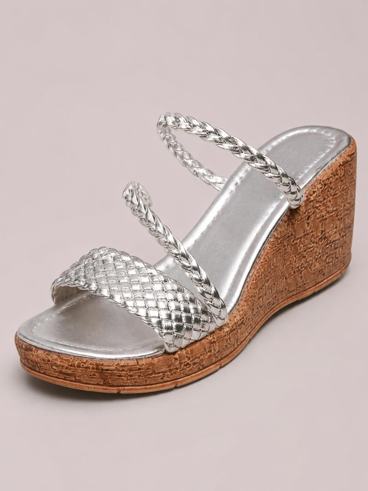 Silver open toe wedge sandals feature braided straps, a textured mid-height wedge sole, and a metallic footbed for a polished look.