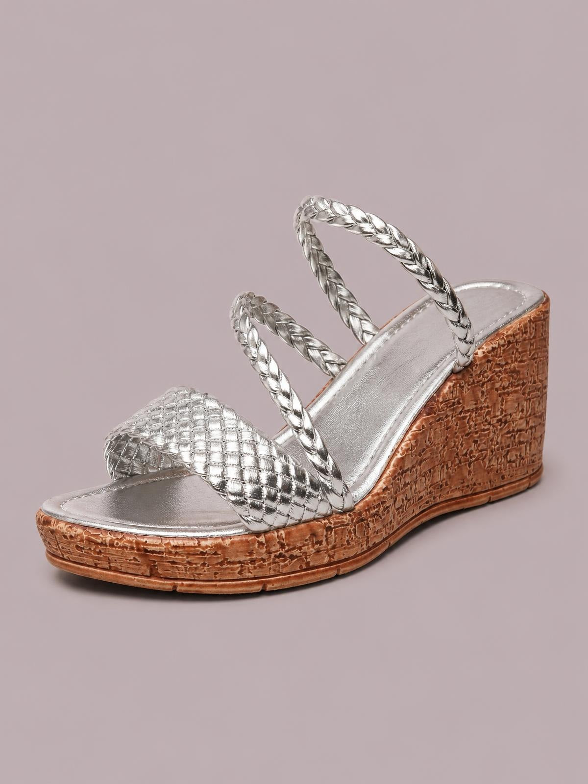 Silver open toe wedge sandal with braided straps, a quilted front band, metallic footbed, and a textured brown mid-height wedge sole.
