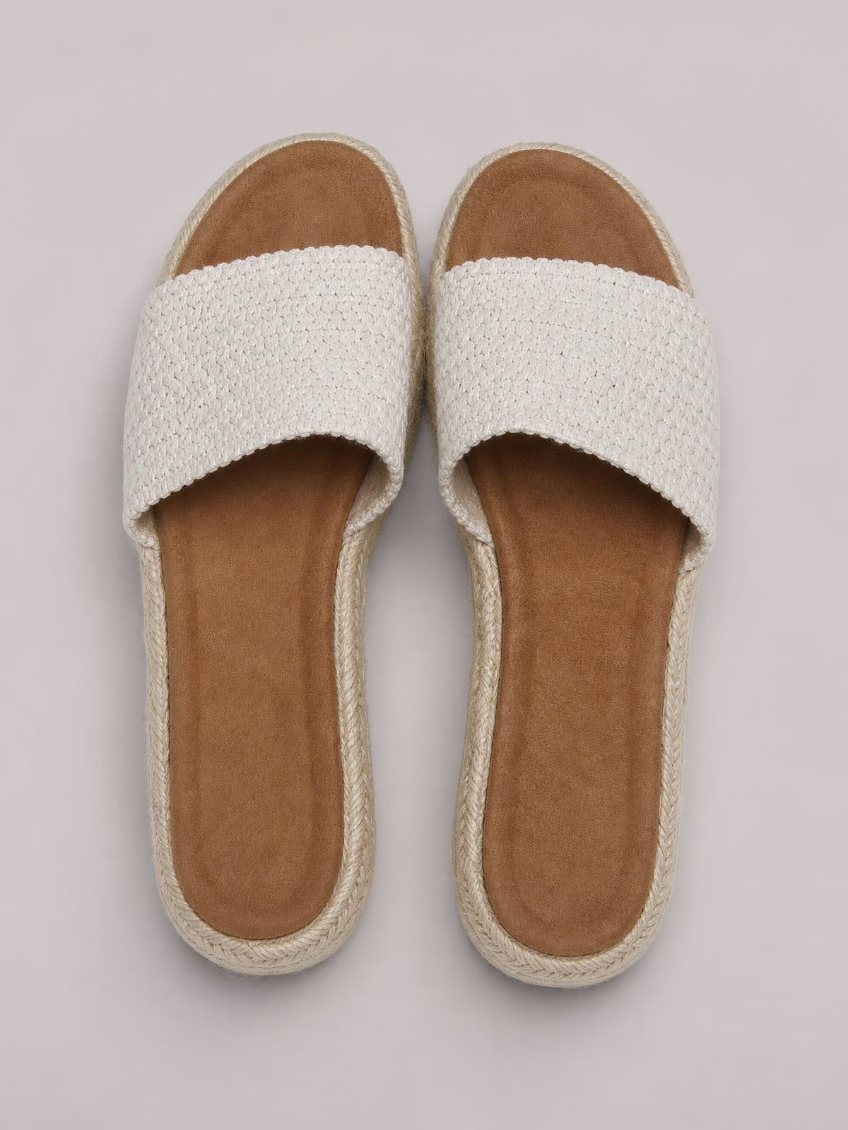 White open-toe woven platform sandals with broad textured straps, tan footbeds, and braided straw-like soles shown from above.
