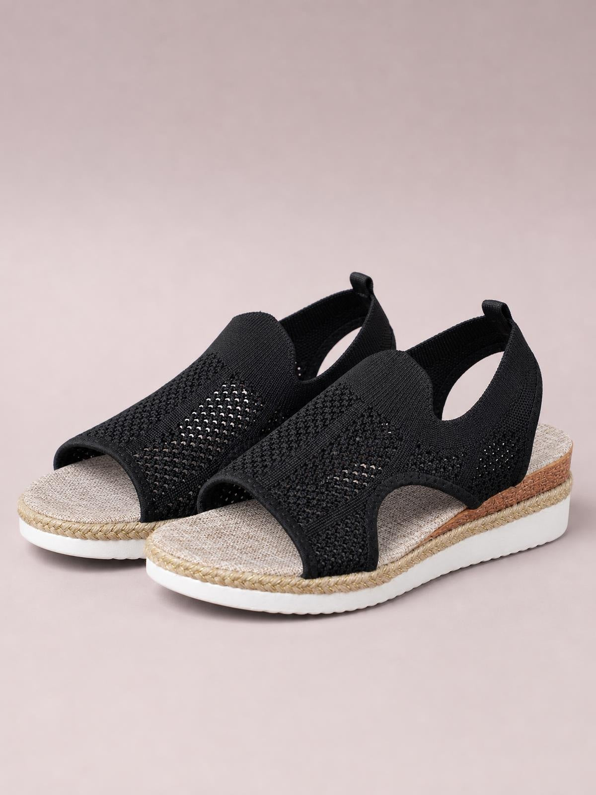 Black open-toe woven wedge sandals with mid-height heels, textured espadrille-style trim, cushioned footbeds, and white rubber platform soles.