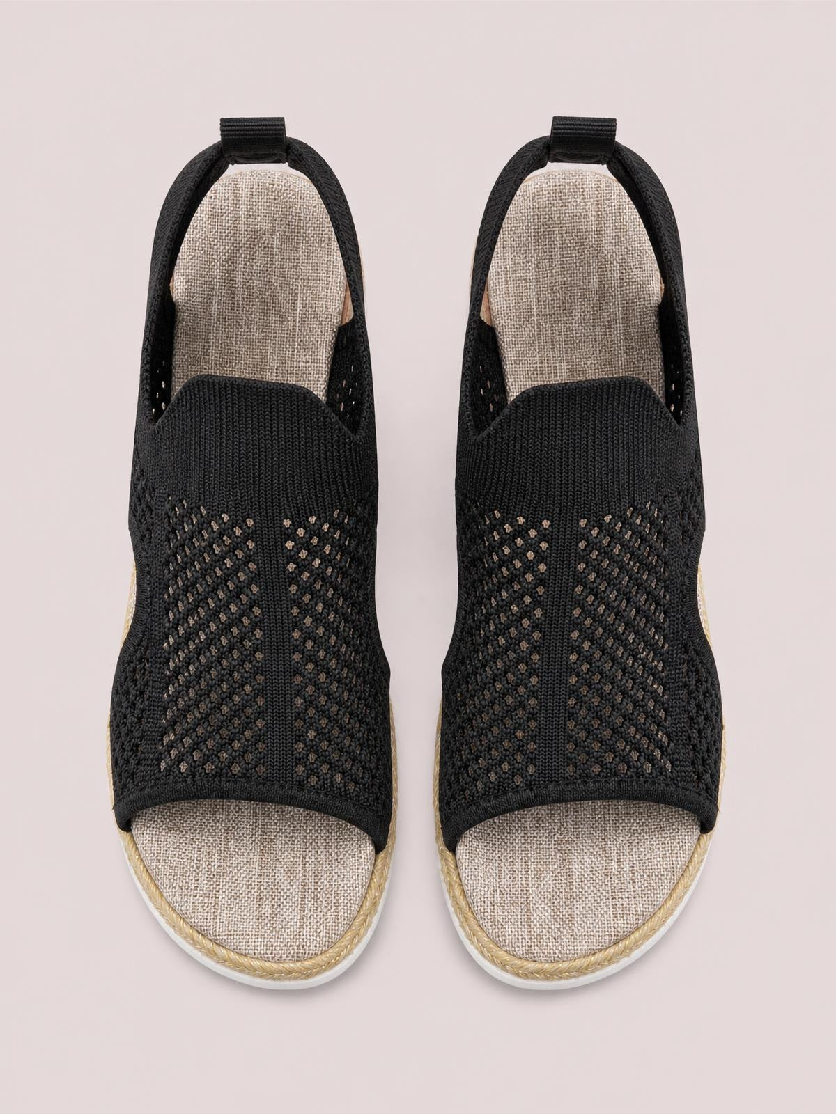 Pair of black open toe woven wedge sandals with breathable patterned uppers, slingback heel loops, cushioned textile footbeds, and rope-trimmed midsoles.
