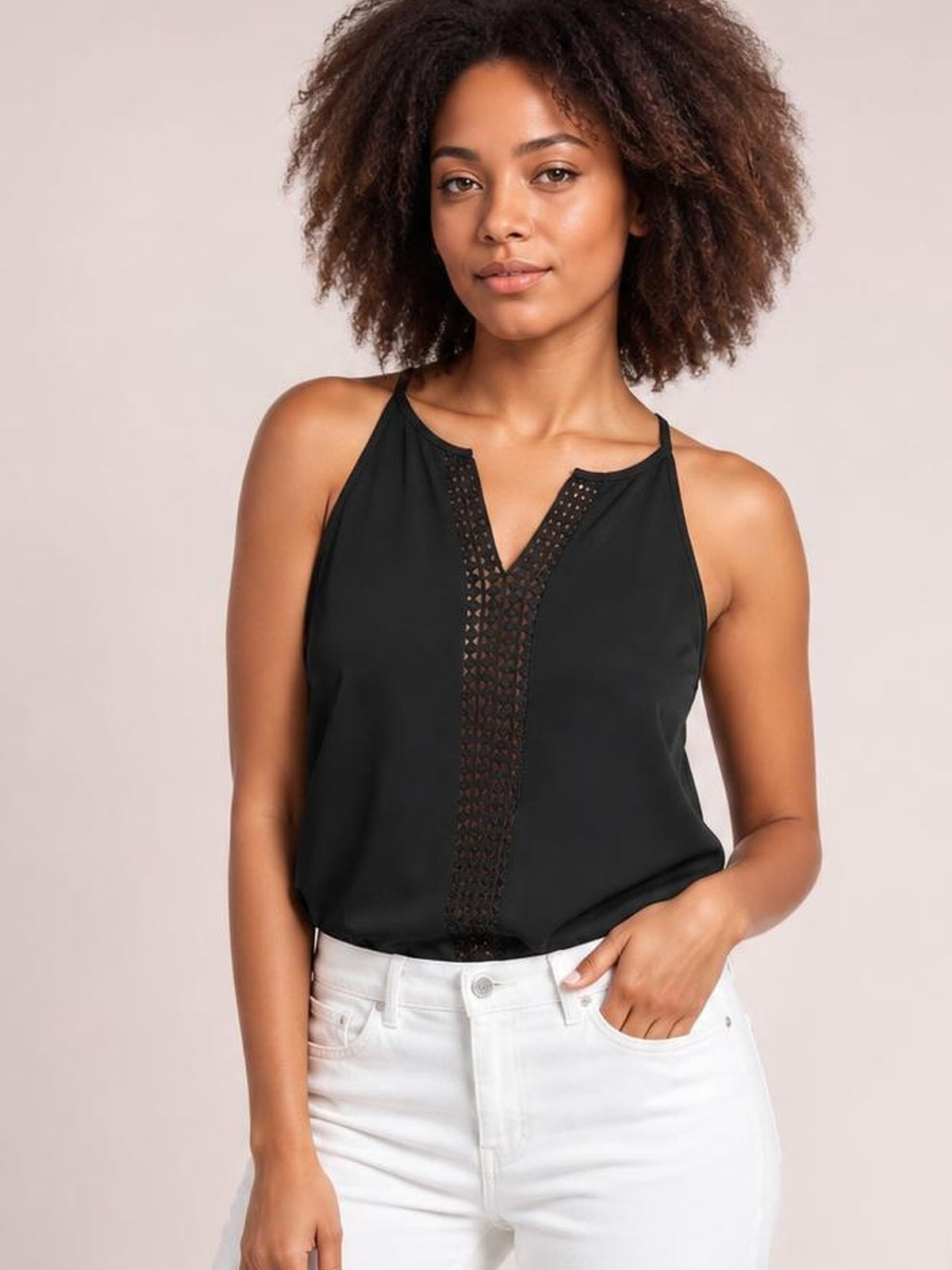 Model wears a black openwork notched cami with slender straps, a semi-sheer center panel, and a relaxed straight silhouette while resting one hand in her pocket.