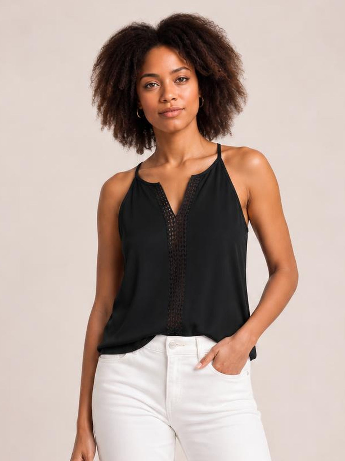 Model poses in a black semi-sheer openwork notched cami with thin straps, a relaxed silhouette, and a vertical lace-like panel at the neckline.