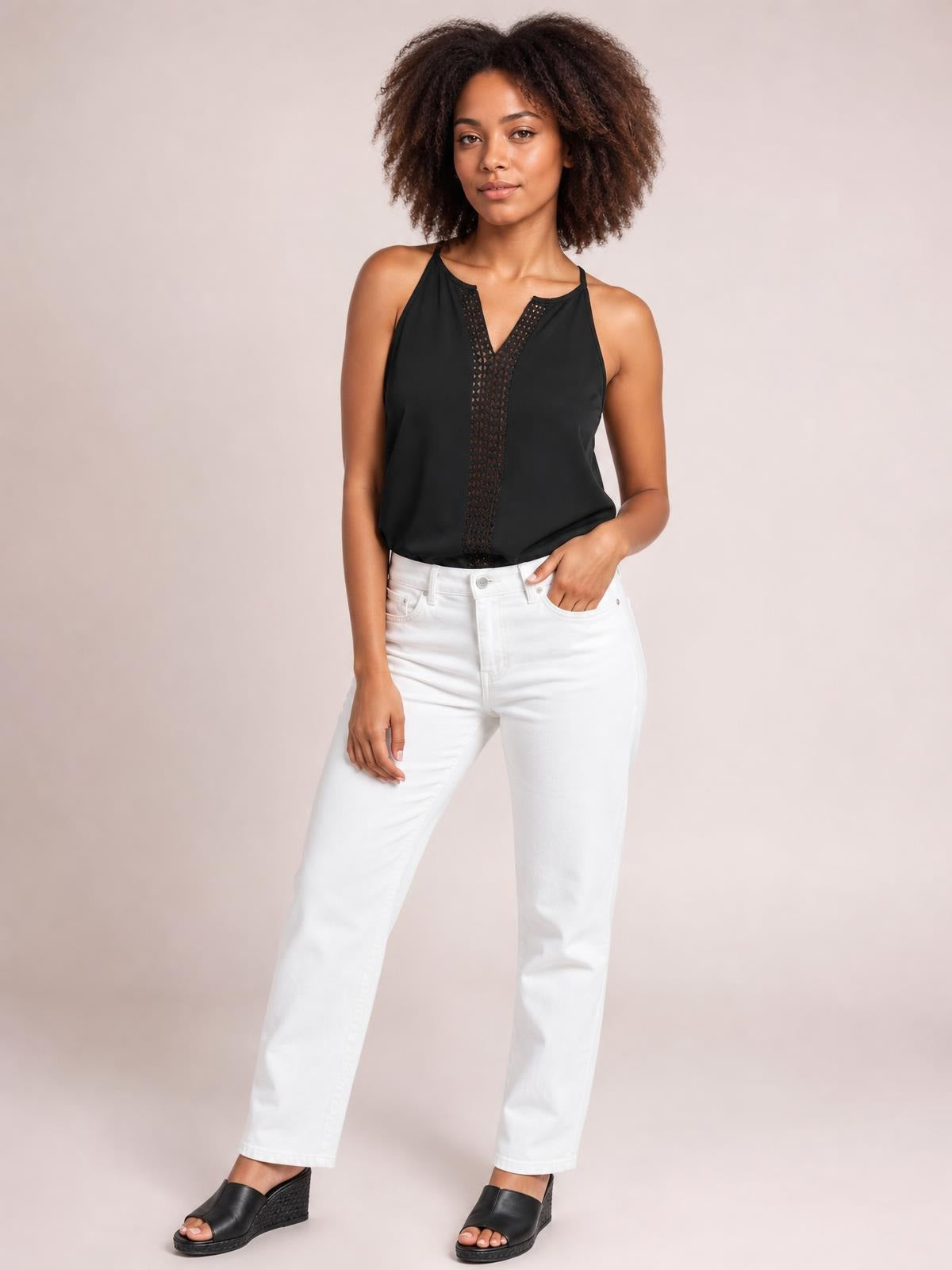 Model stands in a relaxed pose wearing a black openwork notched cami with slim straps, a semi-sheer front panel, and a loose straight silhouette.