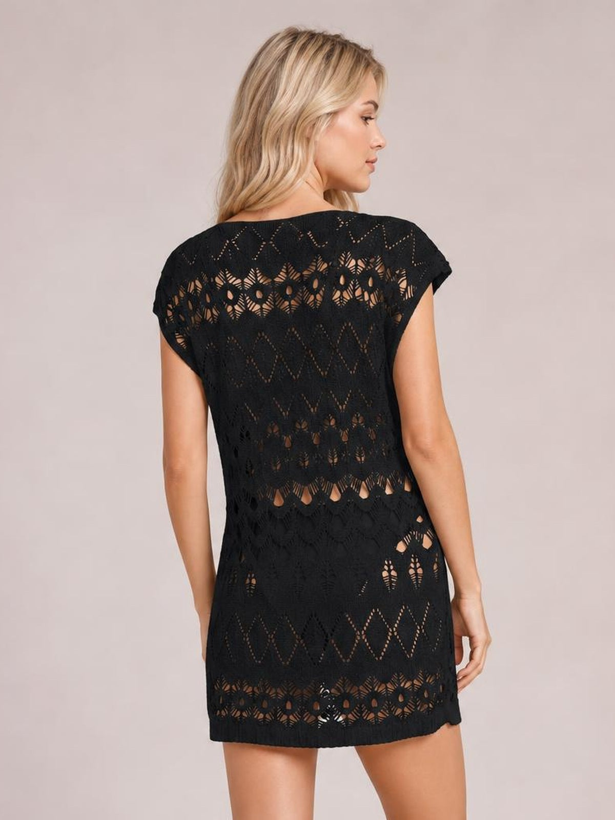Model shown from behind wears a black openwork round neck cover-up with short sleeves, patterned cutouts, and a relaxed straight silhouette.