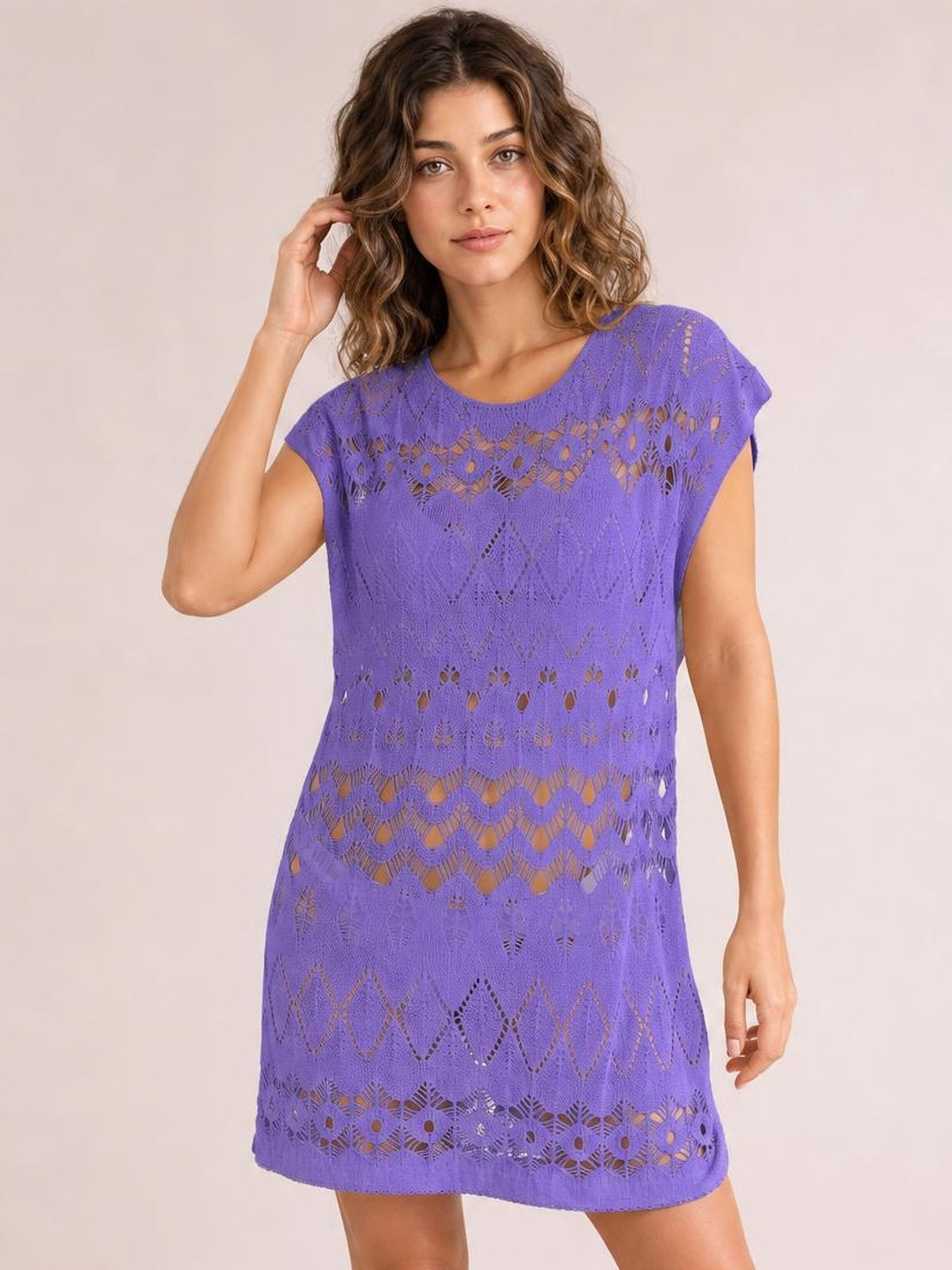 Model wearing a purple openwork round neck cover-up with short sleeves, a relaxed straight silhouette, patterned cutout construction, and a short hem.