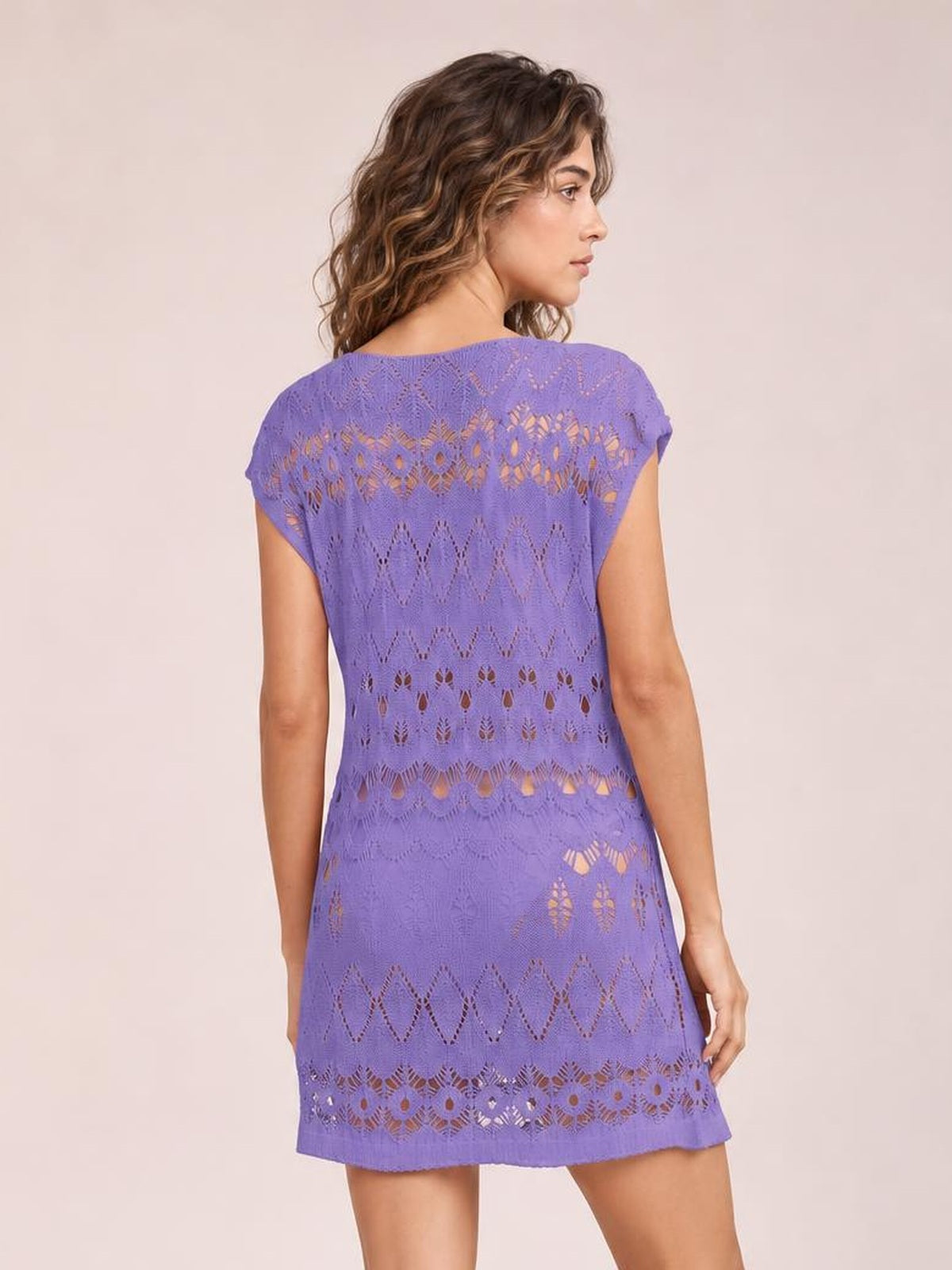 Model shown from the back in a purple openwork round neck cover-up with a relaxed straight silhouette, short sleeves, and patterned cutouts.