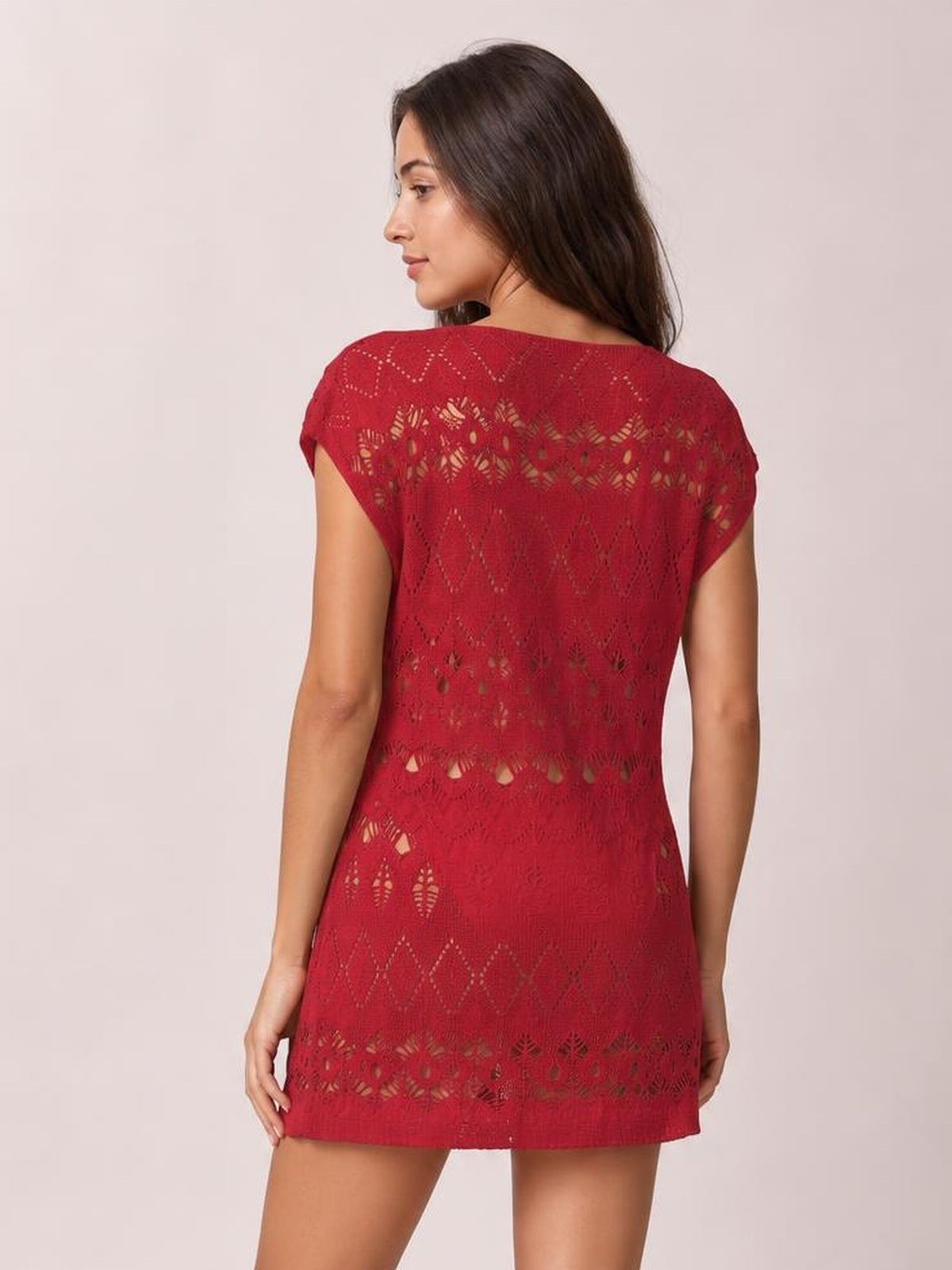 A model looks over her shoulder wearing a red openwork round neck cover-up with short sleeves, a relaxed straight silhouette, and a short hem.