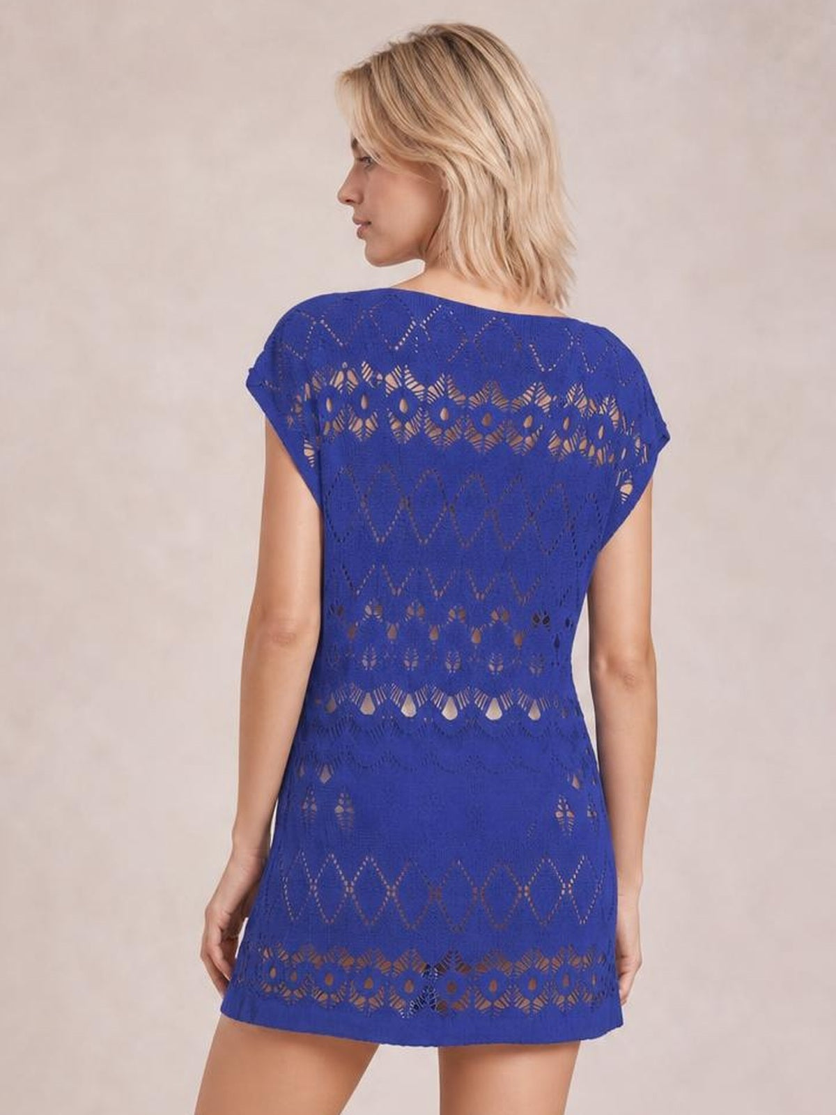 Model shown from behind wearing a royal blue openwork round neck cover-up with short sleeves, patterned cutouts, and a relaxed straight silhouette.