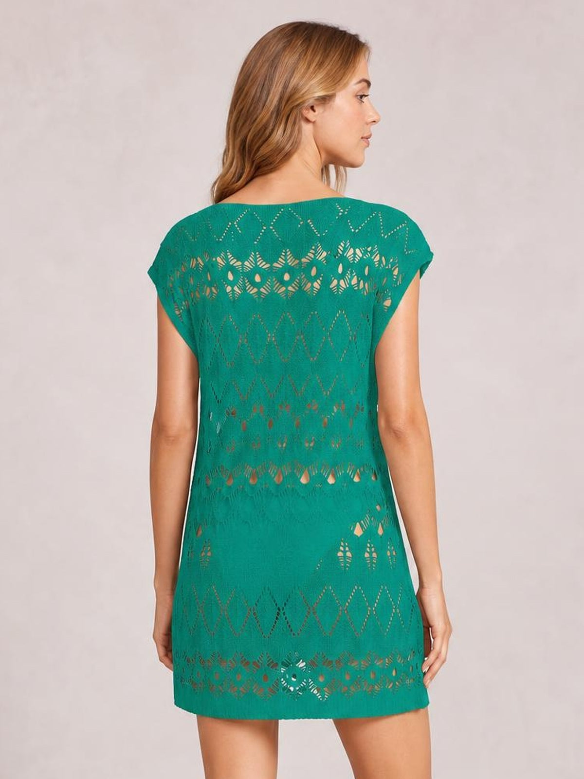 Model shown from the back in a teal openwork round neck cover-up with short sleeves, relaxed straight silhouette, and patterned cutout construction.
