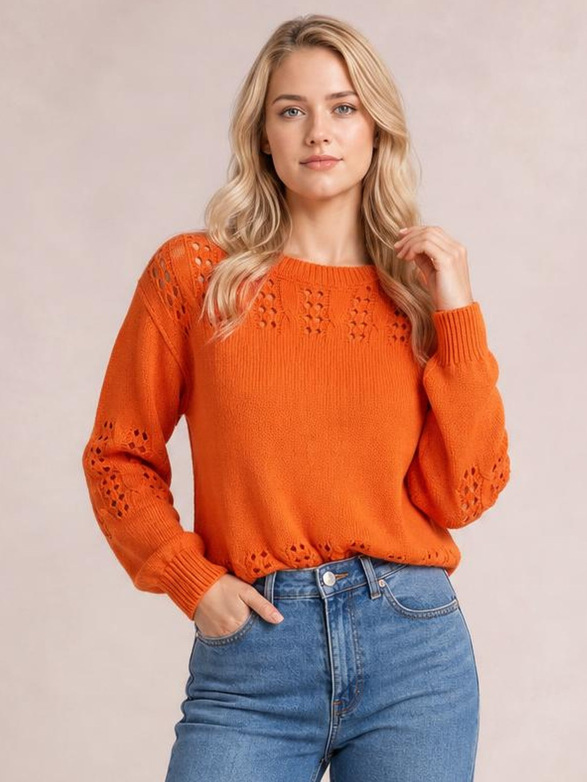 Model poses in a bright orange openwork round-neck sweater with long sleeves, ribbed cuffs and hem, and a relaxed silhouette.
