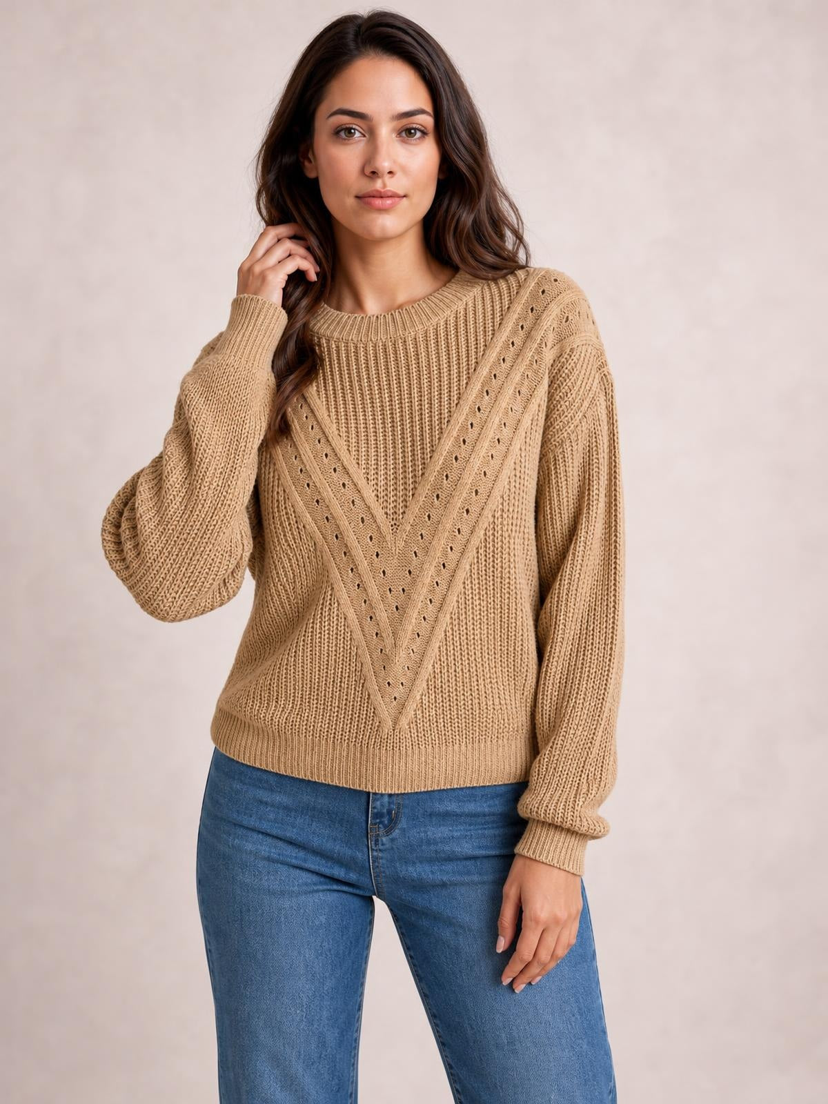 Model poses in a tan openwork round neck sweater with long sleeves, ribbed cuffs and hem, and a relaxed straight silhouette.