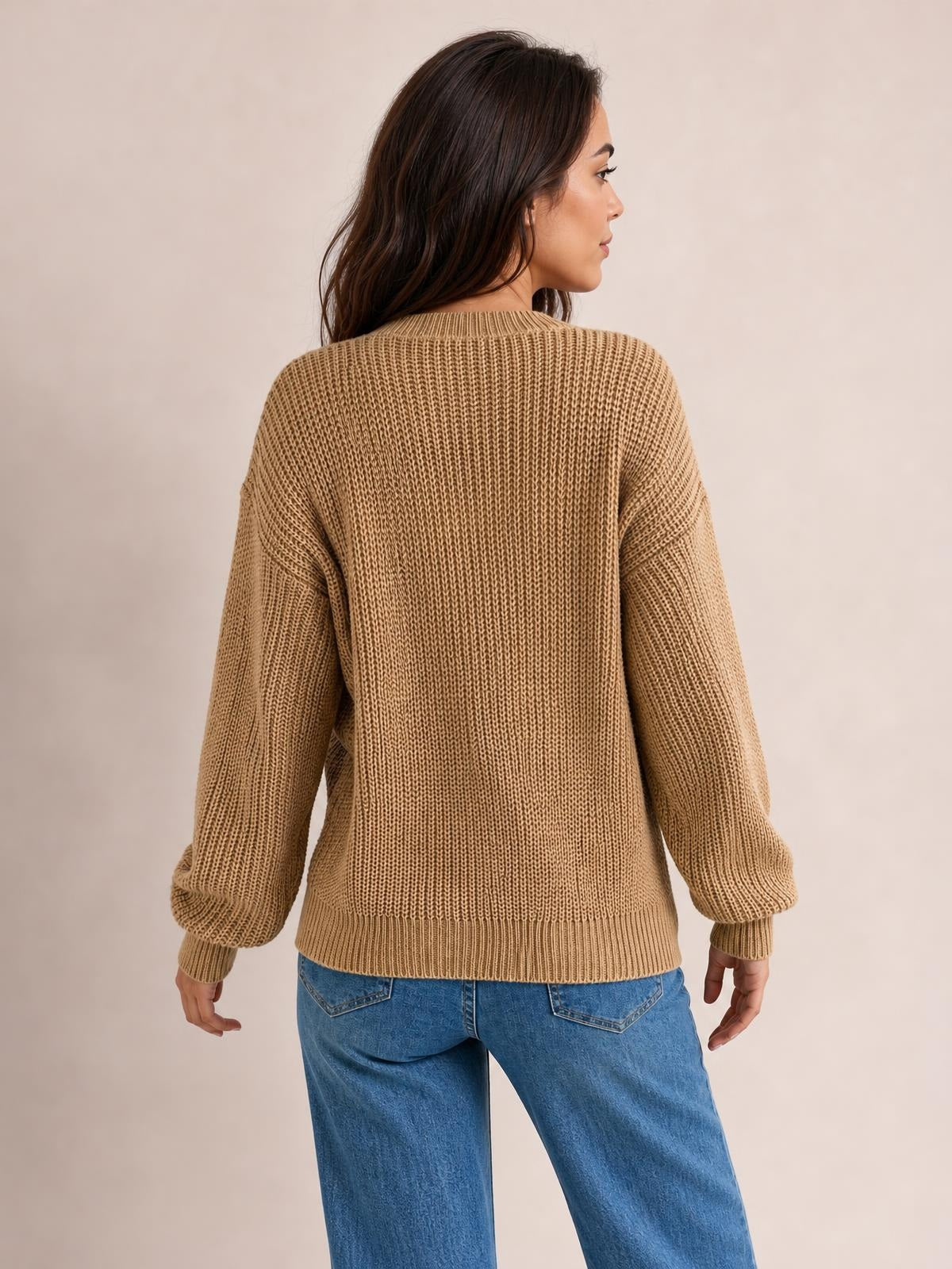 Model shown from behind in a tan openwork round neck sweater with long sleeves, ribbed cuffs and hem, and a relaxed straight silhouette.