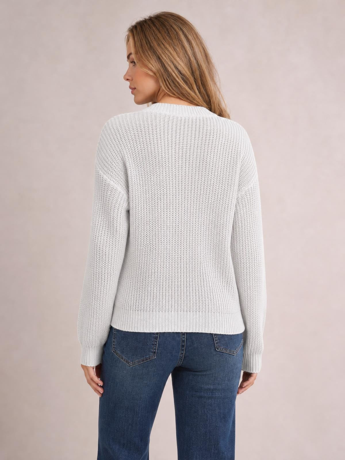 Model shown from the back wearing a white openwork round neck sweater with long sleeves, ribbed trims, and a relaxed straight silhouette.