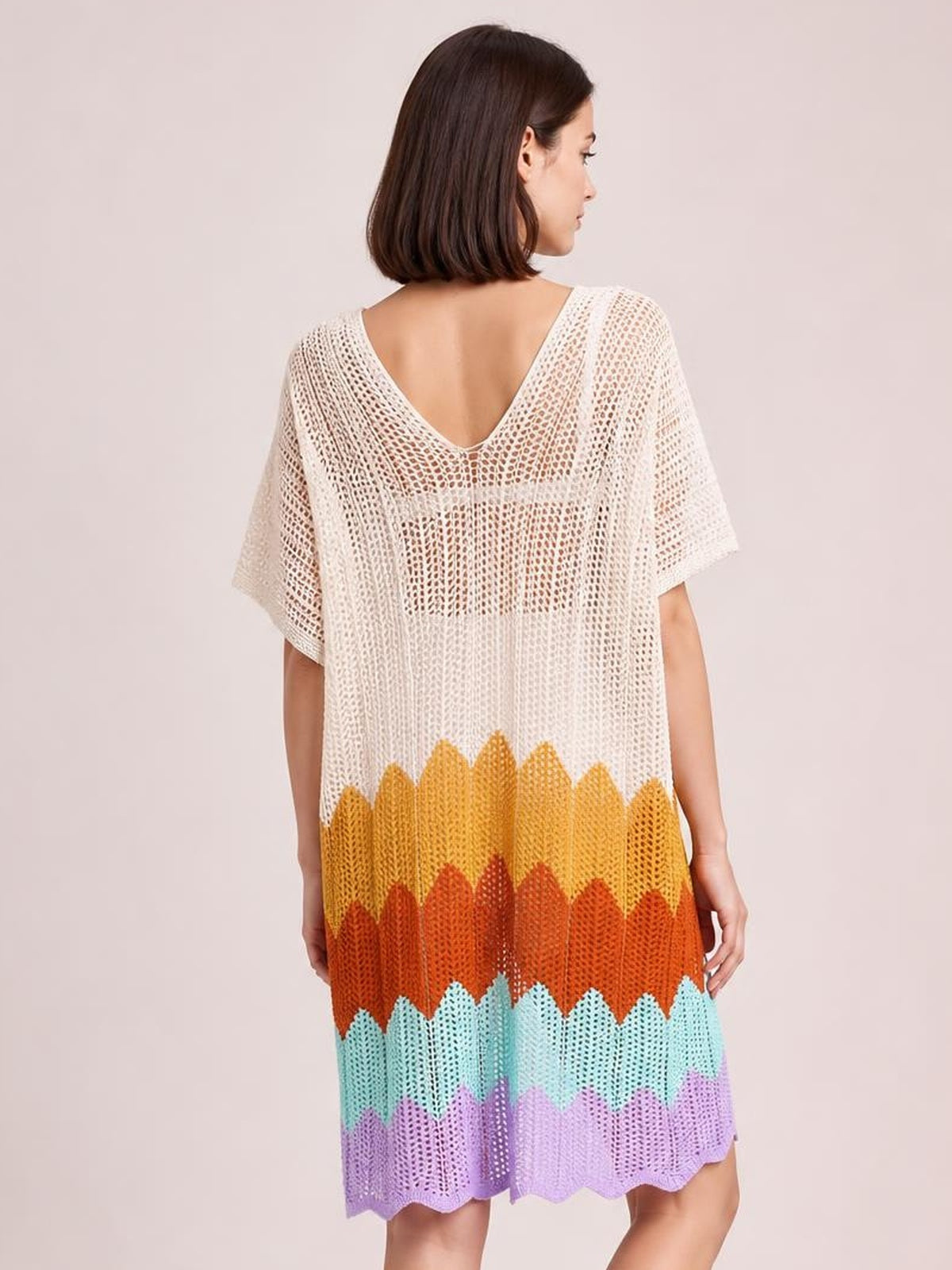 A model stands in a loose openwork V-neck half-sleeve cover-up with a white upper body and colorful scalloped stripes in a flowing silhouette.