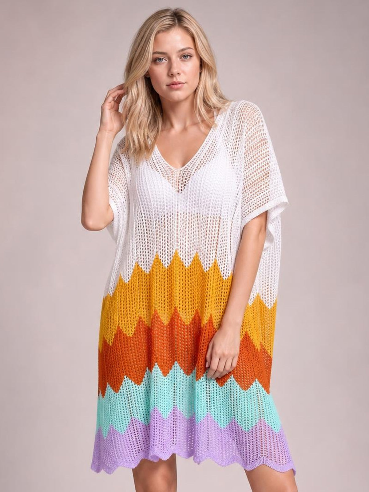 A model poses in a loose, colorful openwork V-neck cover-up with half sleeves, a flowing silhouette, striped knit pattern, and scalloped hem.