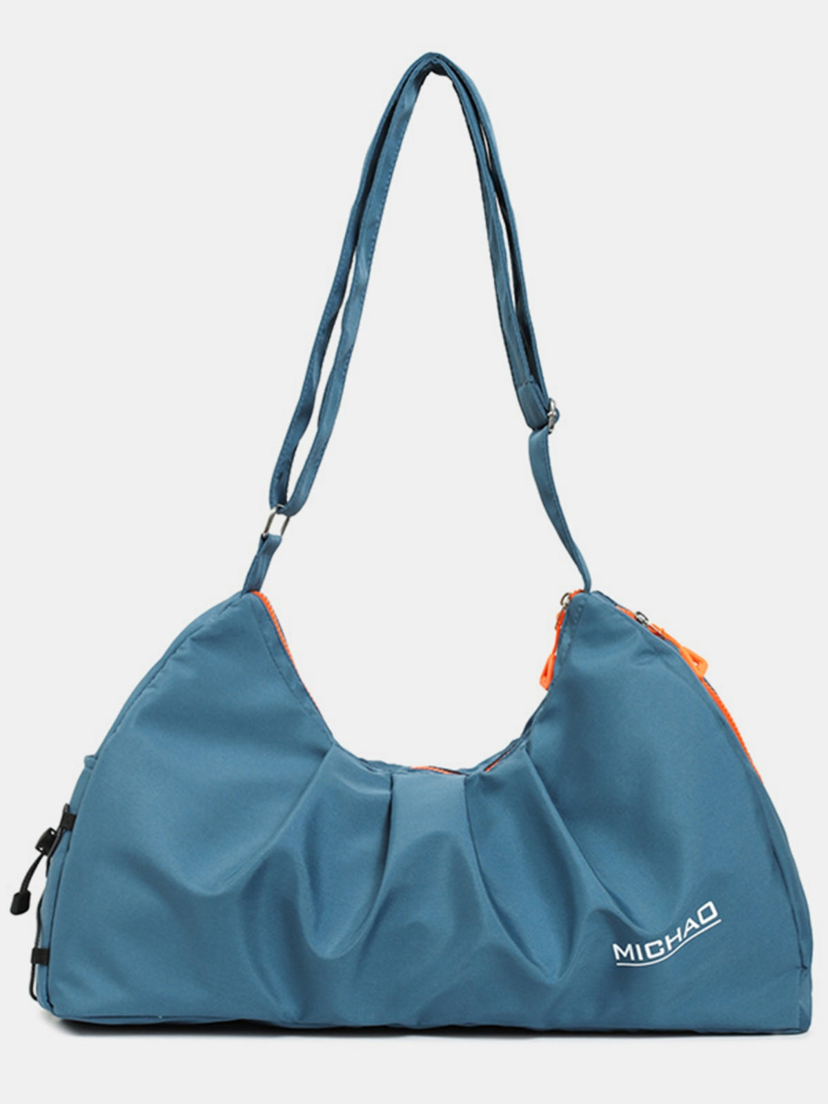Large blue Oxford cloth crossbody bag with a softly slouched silhouette, gathered front, adjustable strap, orange zipper accents, and roomy structured construction.