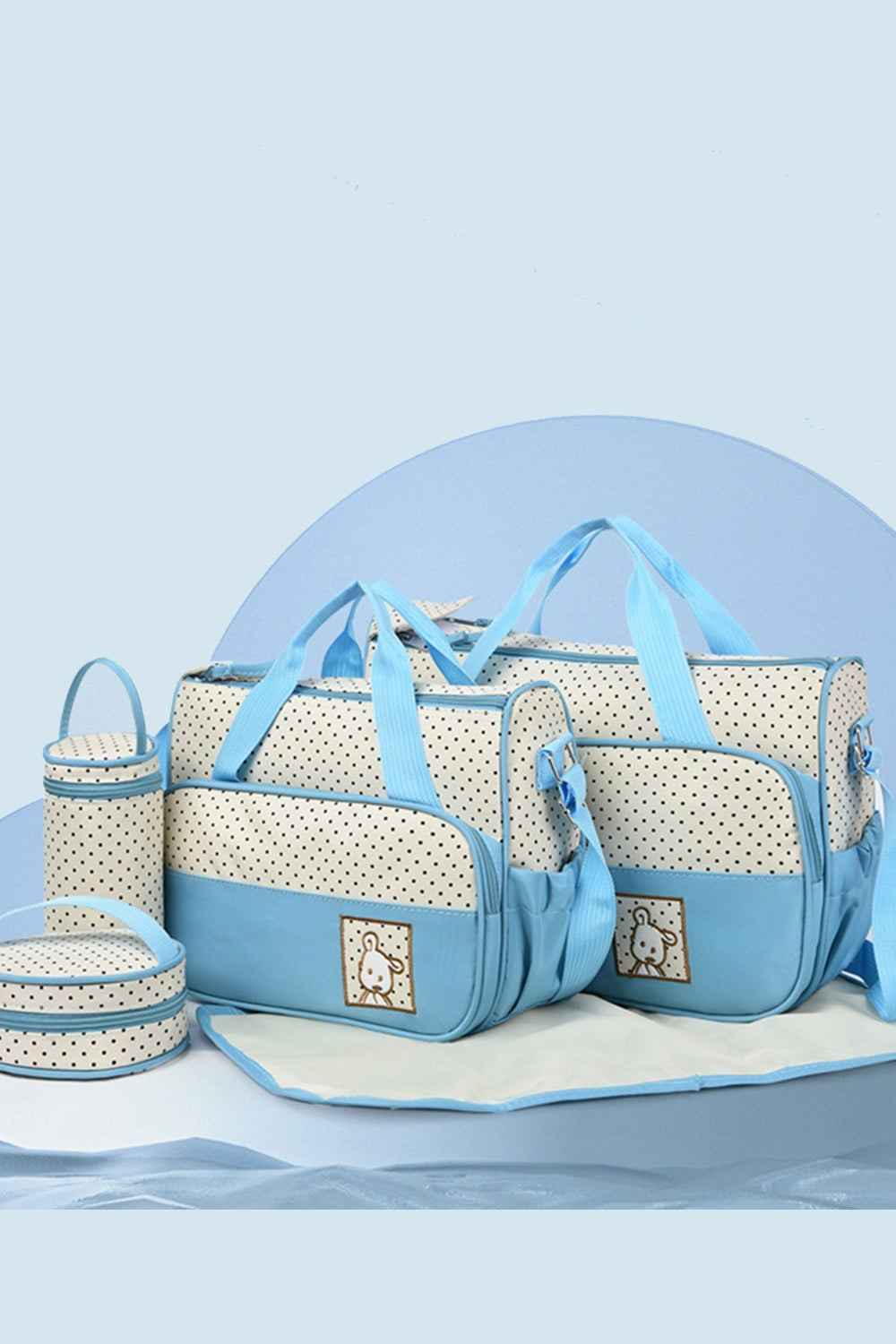 A blue and cream Oxford cloth 4-piece bag set features contrast trim, structured totes with top handles, matching bottle and meal bags, and a diaper pad.