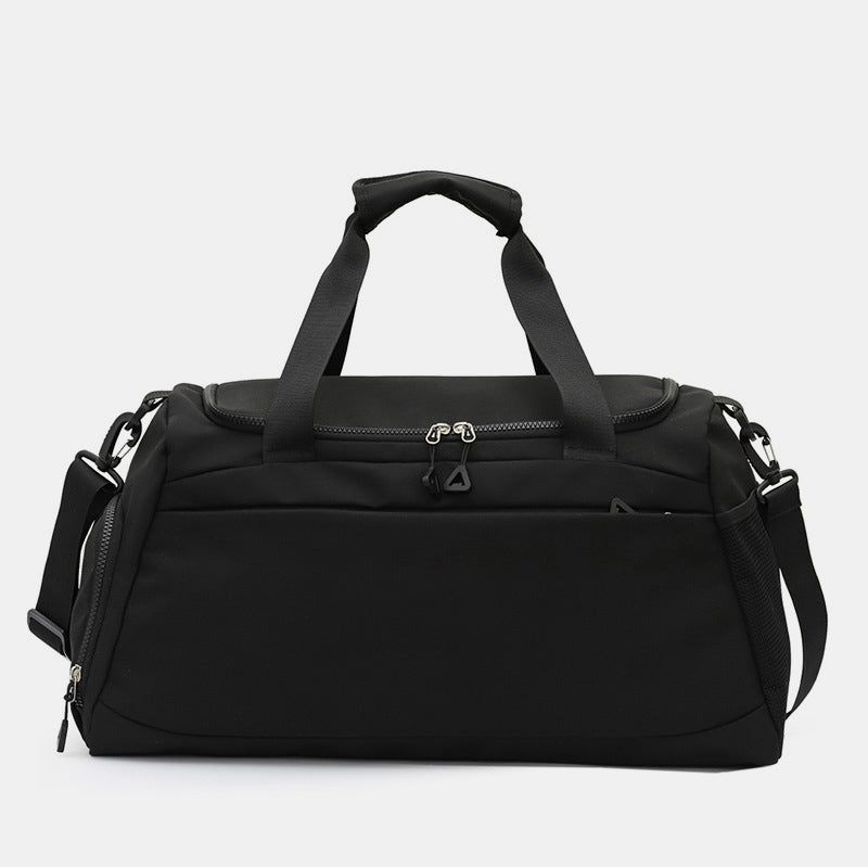 Black oversize Oxford cloth travel bag with a roomy duffel silhouette, dual top handles, adjustable shoulder strap, and multiple zippered pockets.