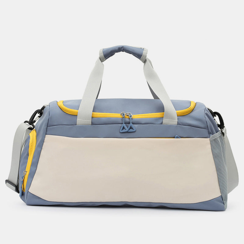 Oversize blue and cream Oxford cloth travel duffel with dual top handles, adjustable shoulder strap, yellow zippers, and multiple zippered pockets.