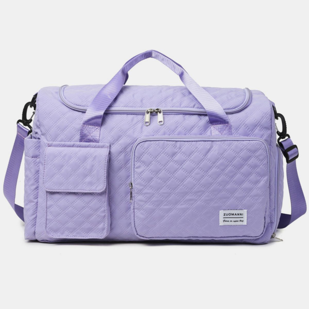 Oversize lavender Oxford cloth travel bag with a quilted duffel silhouette, zip-top closure, multiple front pockets, top handles, and an adjustable shoulder strap.