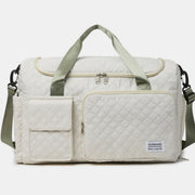 Oversize white quilted Oxford cloth travel bag with a roomy duffel silhouette, multiple front pockets, sturdy top handles, zip closure, and detachable shoulder strap.