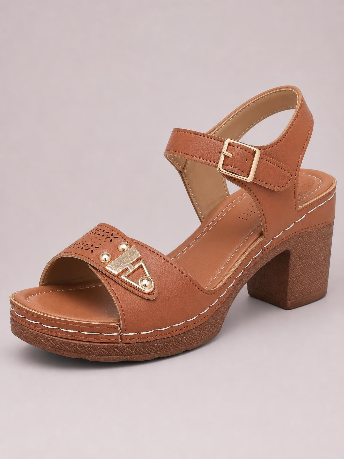 Brown peep toe block heel sandals feature a platform sole, adjustable ankle strap with buckle, perforated front strap, and metallic decorative detail.