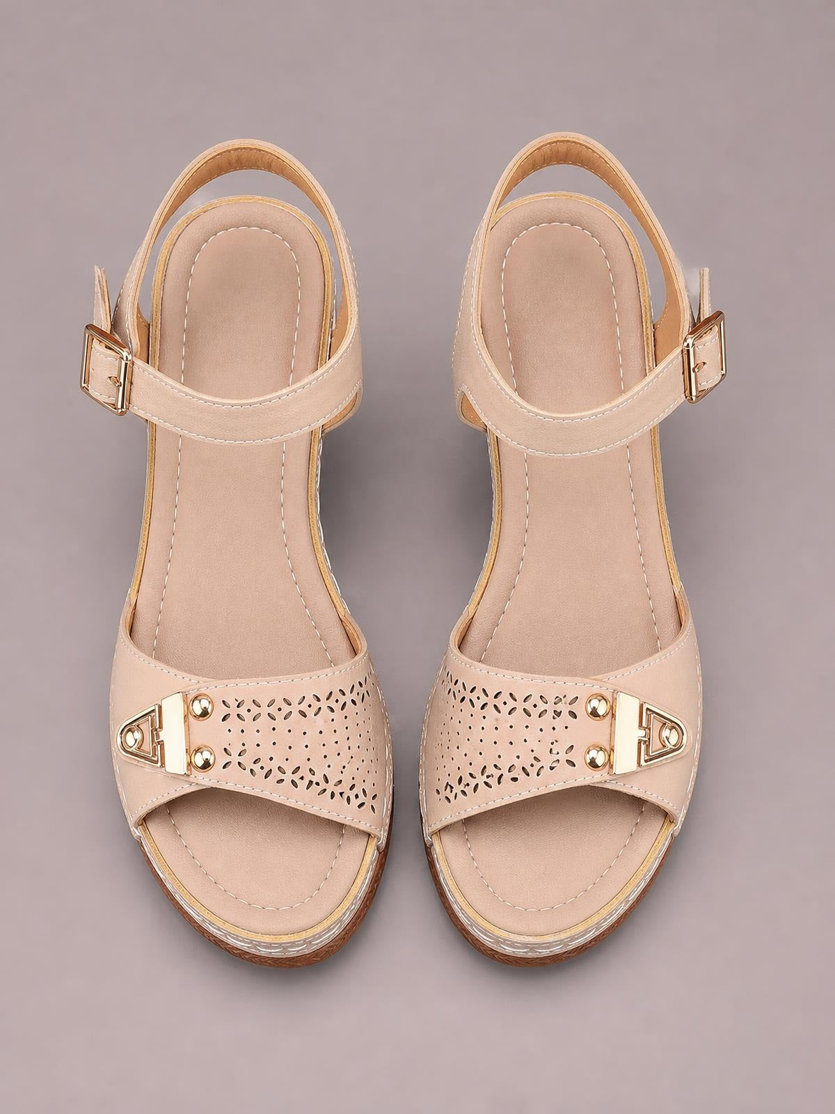 Beige peep toe block heel sandals with perforated crossover straps, gold-tone buckle accents, stitched footbeds, and adjustable ankle straps.