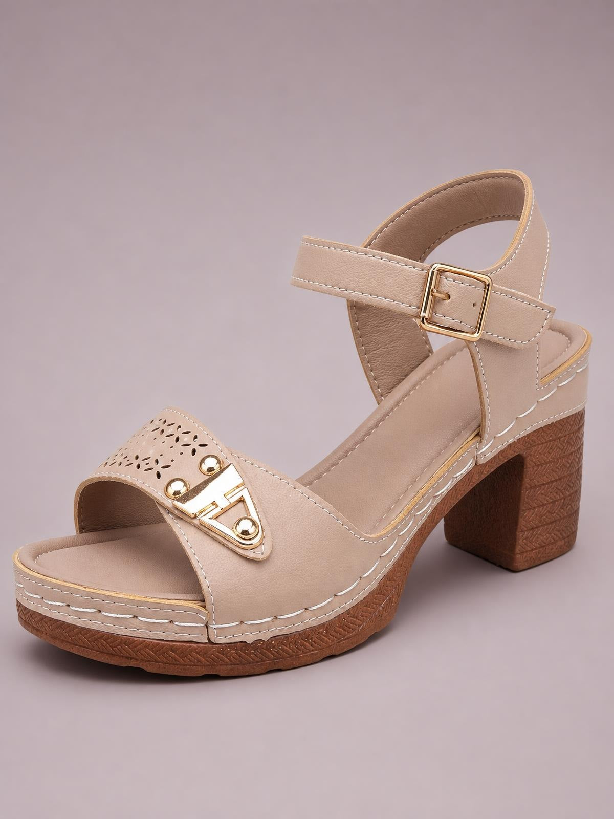 Beige peep toe block heel sandals feature mid-height textured heels, perforated vamp panels, gold-tone accents, ankle straps, buckles, and contrast stitching.