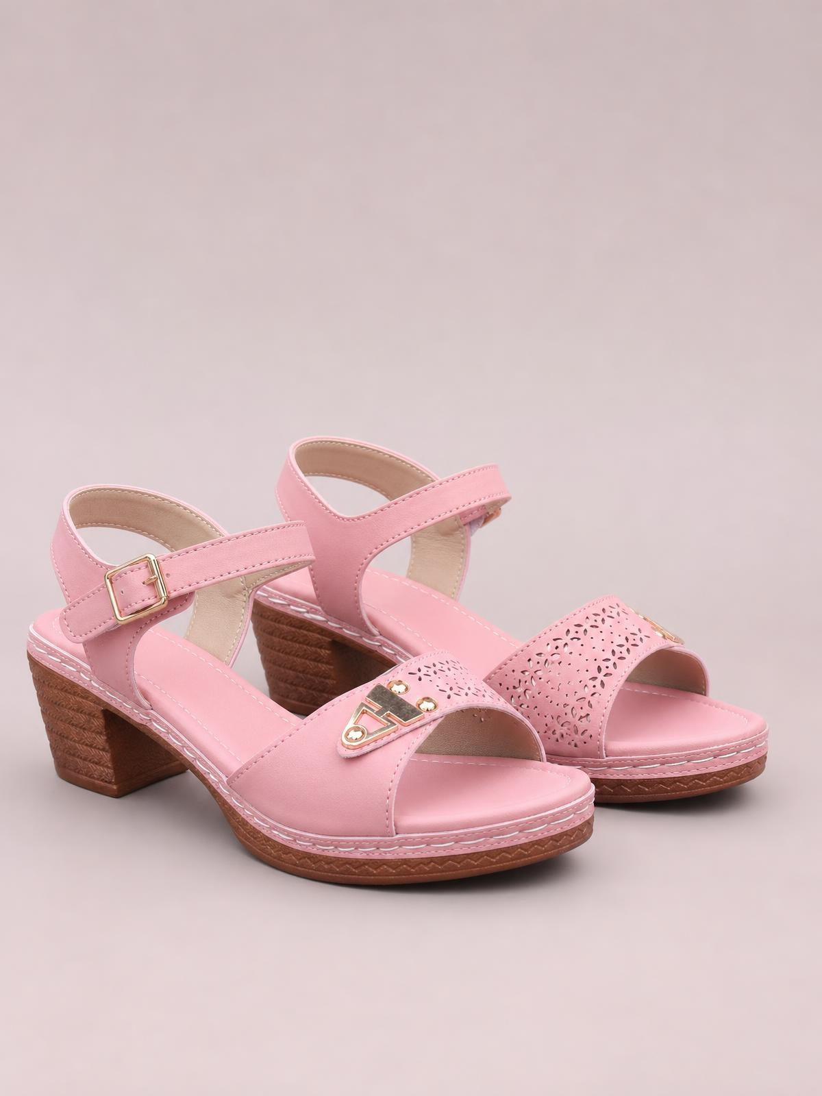 Pink peep toe block heel sandals feature perforated wide straps, ankle buckles, cushioned footbeds, stitched soles, and sturdy mid-height heels.
