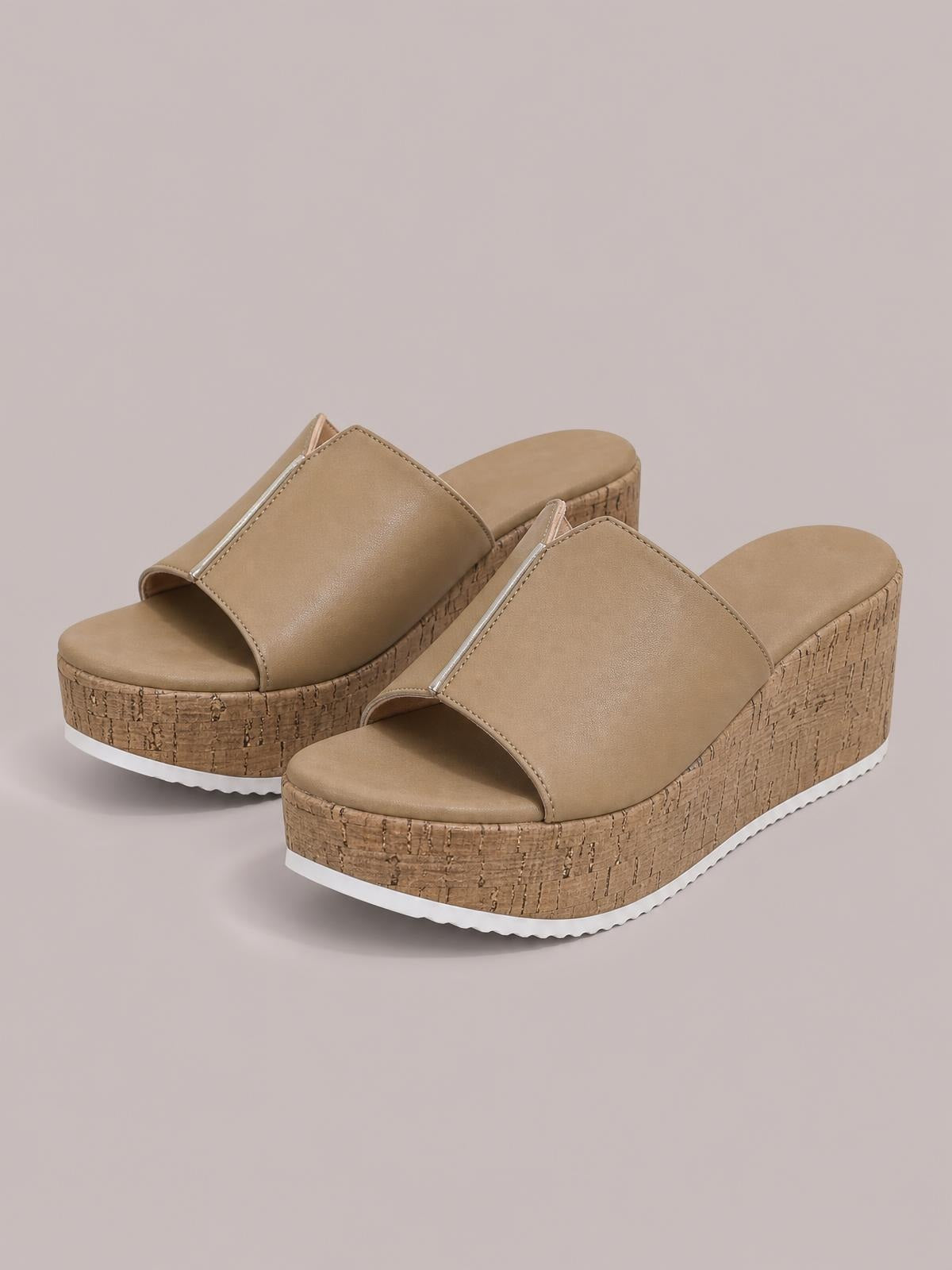 Tan peep toe high heel sandals feature wide stitched straps, towering cork-textured wedge platforms, and contrasting white rubber soles.