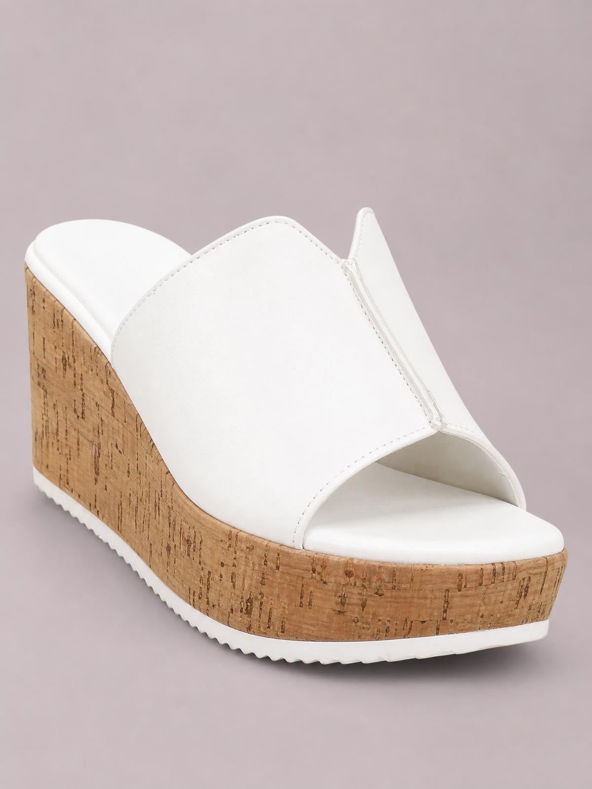 White peep-toe high heel sandal with a smooth wide upper, tall cork-textured wedge platform, and white ridged outsole.