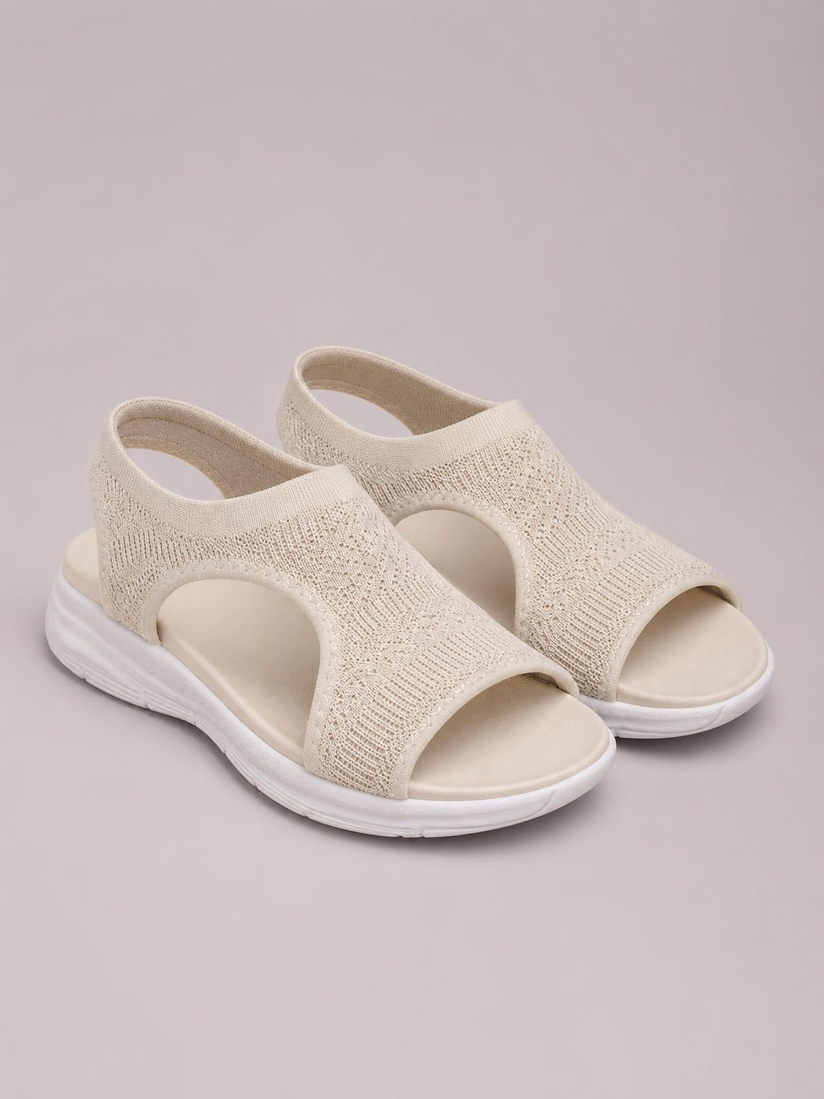 Cream solid-color peep-toe sandals feature textured cloth uppers, open side cutouts, wide straps, and cushioned flat white rubber soles.