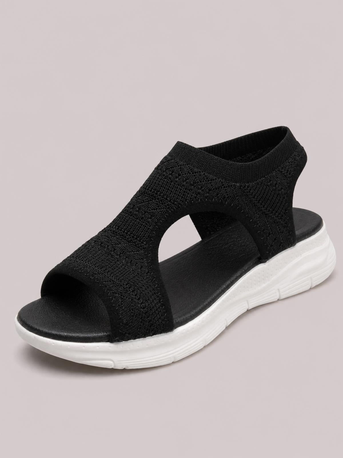 Black solid-color peep-toe sandals feature a textured cloth upper with open sides, an ankle collar, cushioned footbed, and a white rubber flat sole.