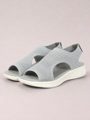 Light gray solid-color peep-toe sandals feature textured cloth uppers, wide side cutouts, open toes, and flat rubber soles with a subtle tread.