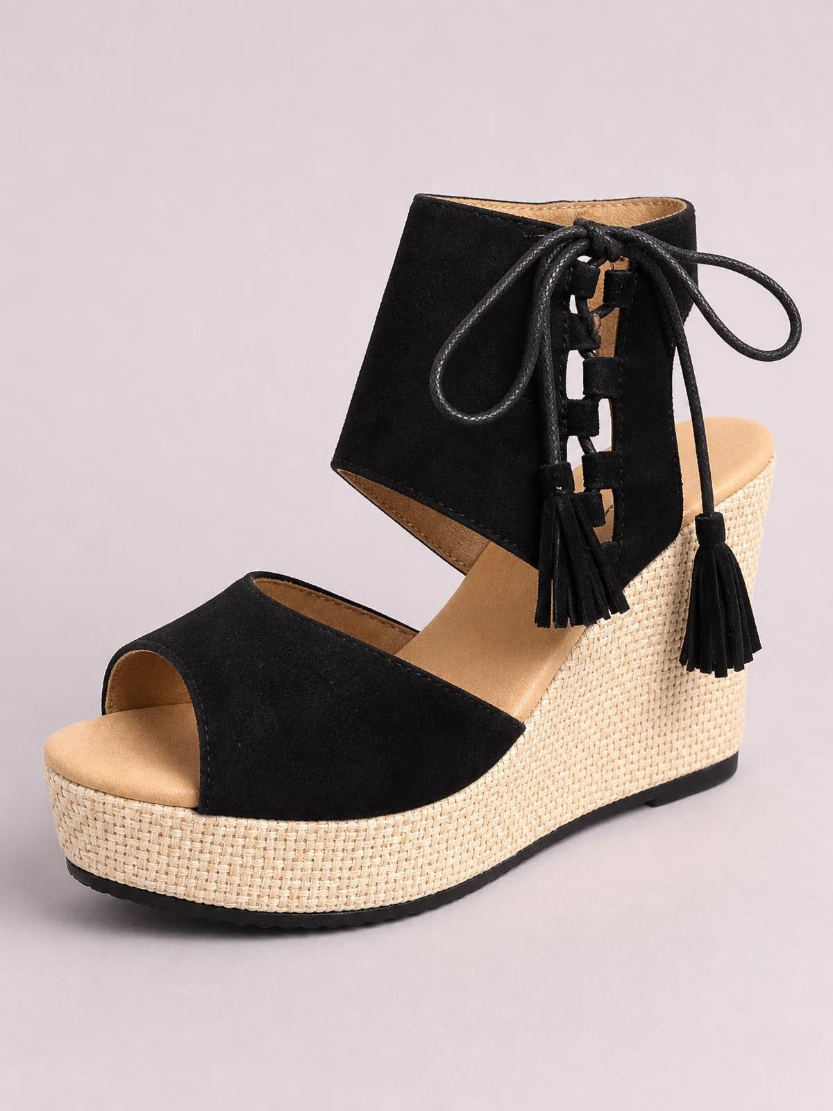 Black suede peep toe wedge sandals feature lace-up ankle straps with tassels, a woven espadrille platform, and a comfortable mid-height wedge heel.