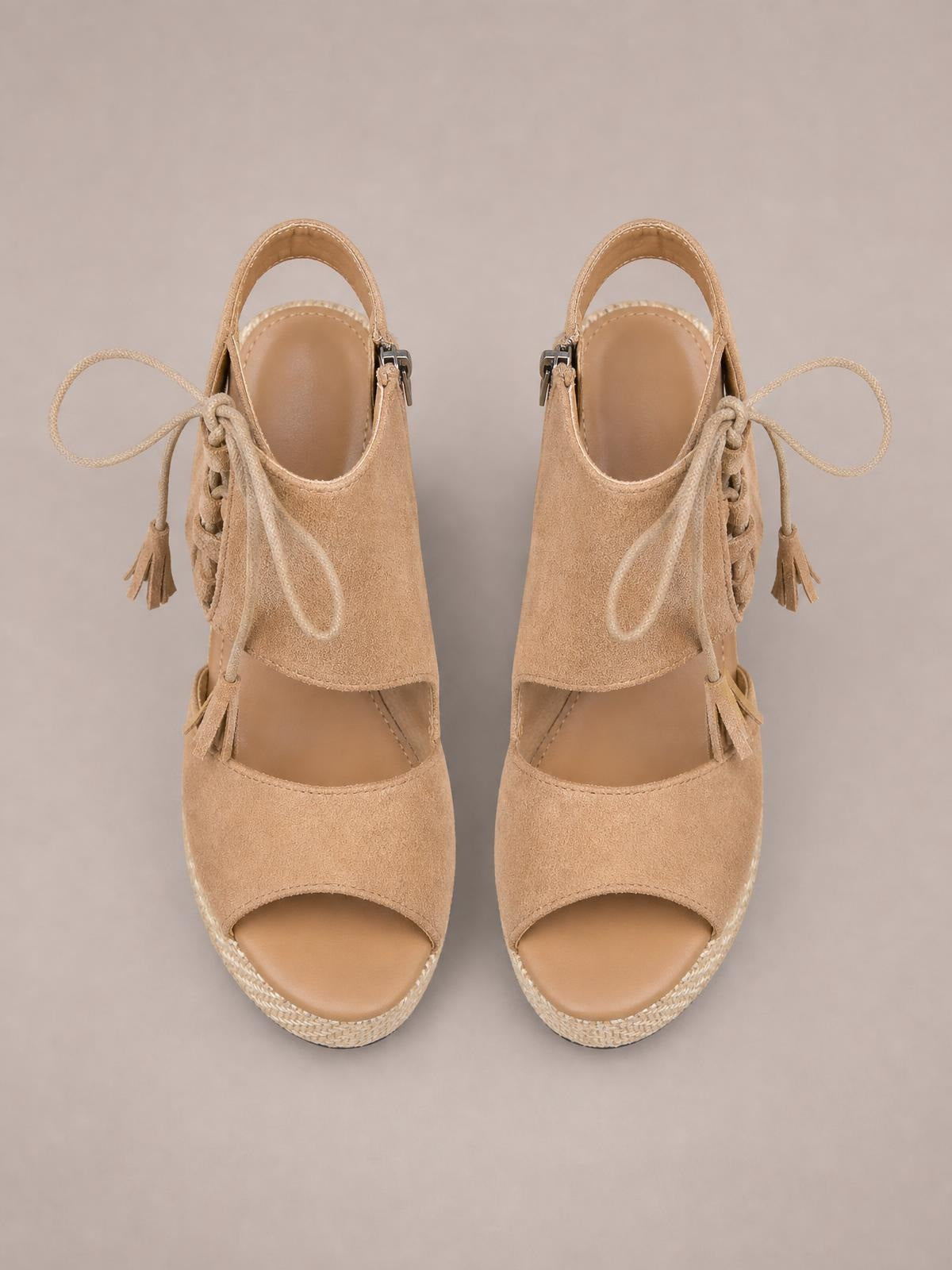 Tan suede peep toe wedge sandals feature lace-up ankle straps with tassel ties, open sides, and a braided mid-height wedge sole.