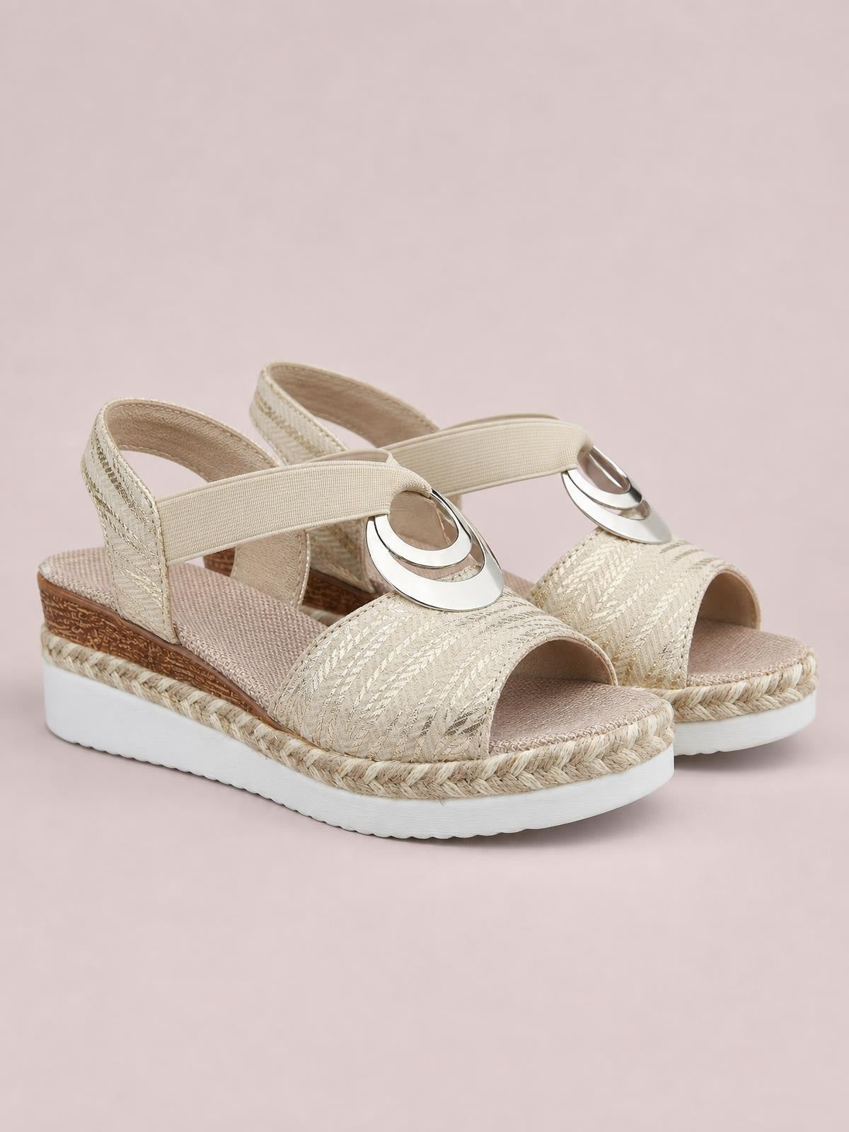 Cream peep toe wedge sandals feature textured woven straps, circular metallic accents, espadrille-style trim, and a white platform sole.
