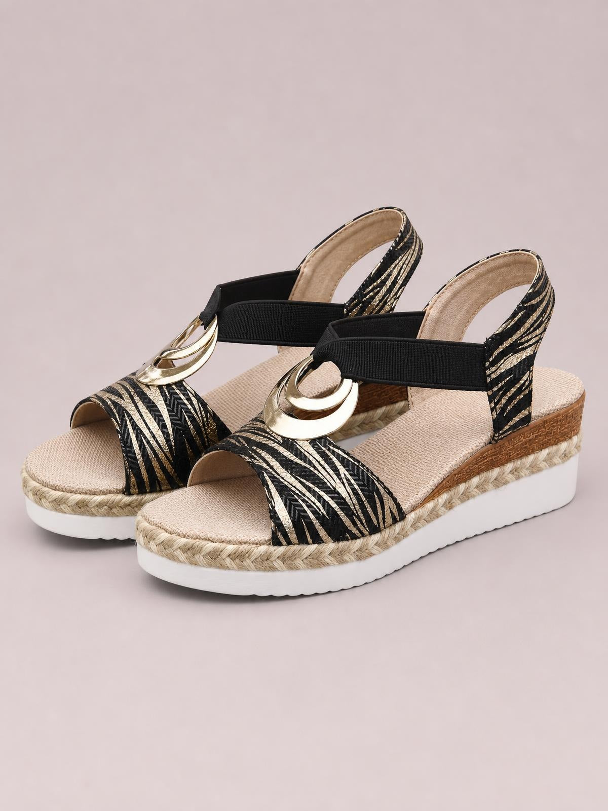 Black-and-gold peep toe wedge sandals feature zebra-striped straps, ankle bands with circular gold-tone accents, woven espadrille trim, and white platform soles.