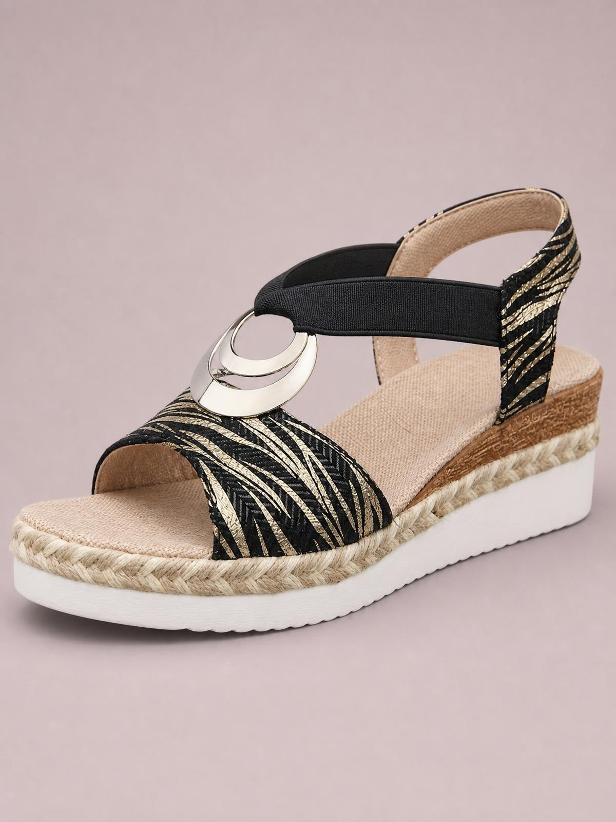 Black-and-gold peep toe wedge sandals feature a patterned vamp, circular metal ornament, ankle strap, woven espadrille trim, and white platform sole.