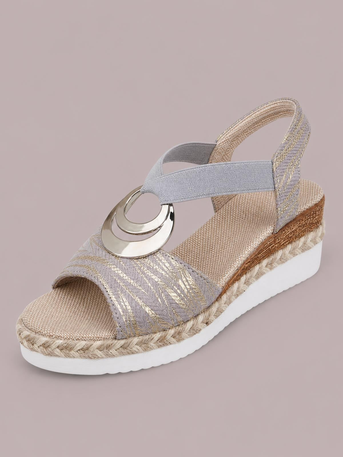 Gray and gold peep toe wedge sandals feature a striped upper, circular metal ornament, slingback straps, woven espadrille trim, and a white rubber platform sole.