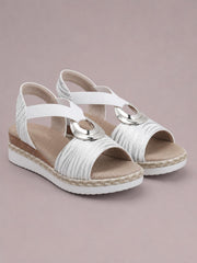 White peep toe wedge sandals with textured patterned straps, silver ring accents, braided trim, cushioned footbeds, and mid-height wedge soles.